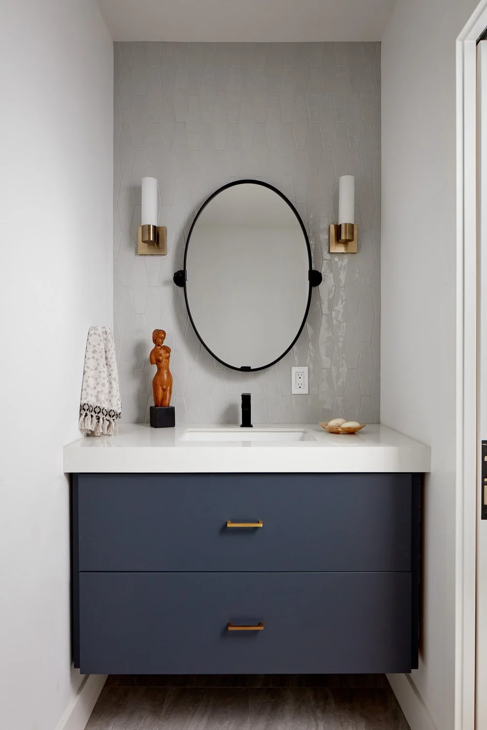 A clean, modern vanity designed with custom storage and finishes for this new construction bathroom.
