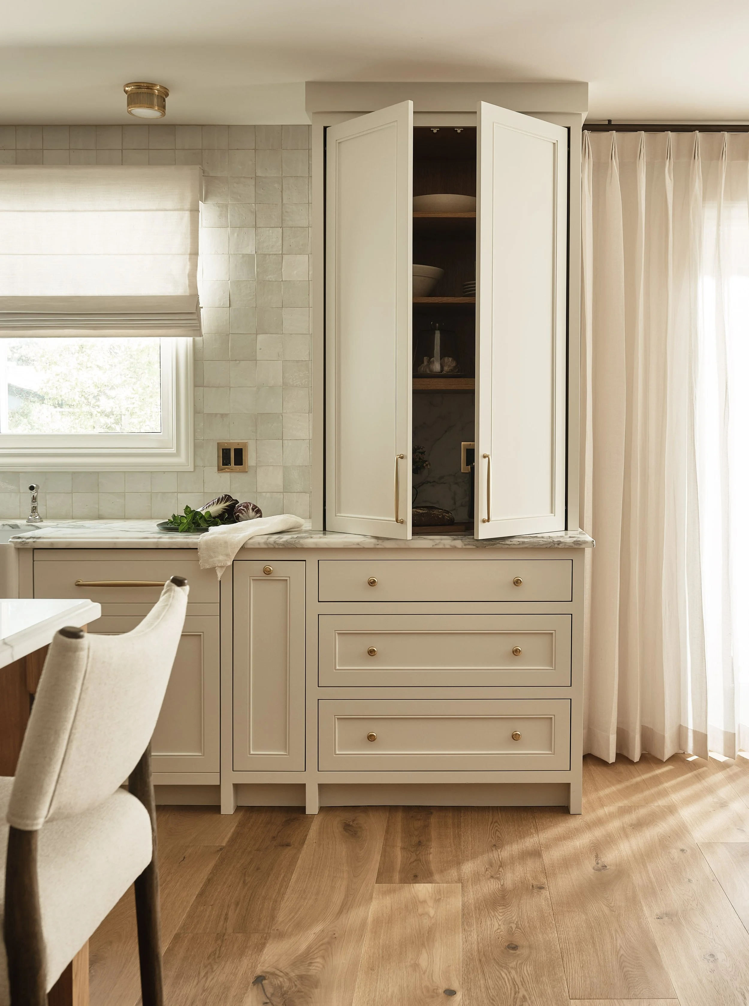 Bright and airy kitchen with marble backsplash and custom millwork in this Addition & Full Home Remodel.