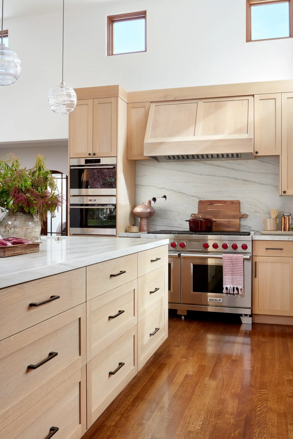 Luxury kitchen remodel featuring a professional range, custom hood, and stone backsplash in this San Mateo full home renovation.