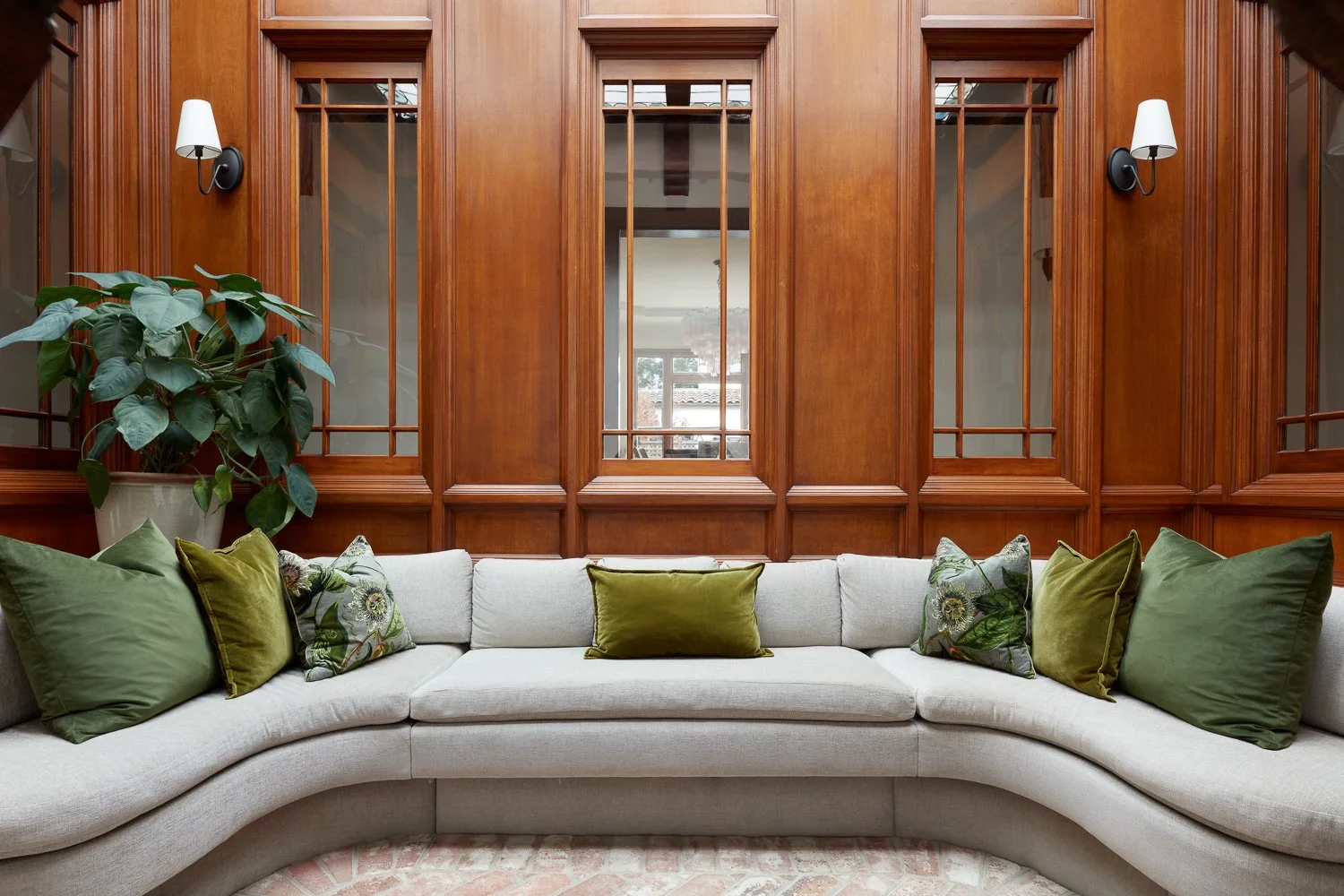 This custom atrium blends rich wood paneling with soft seating for a calm, welcoming retreat inside the home.