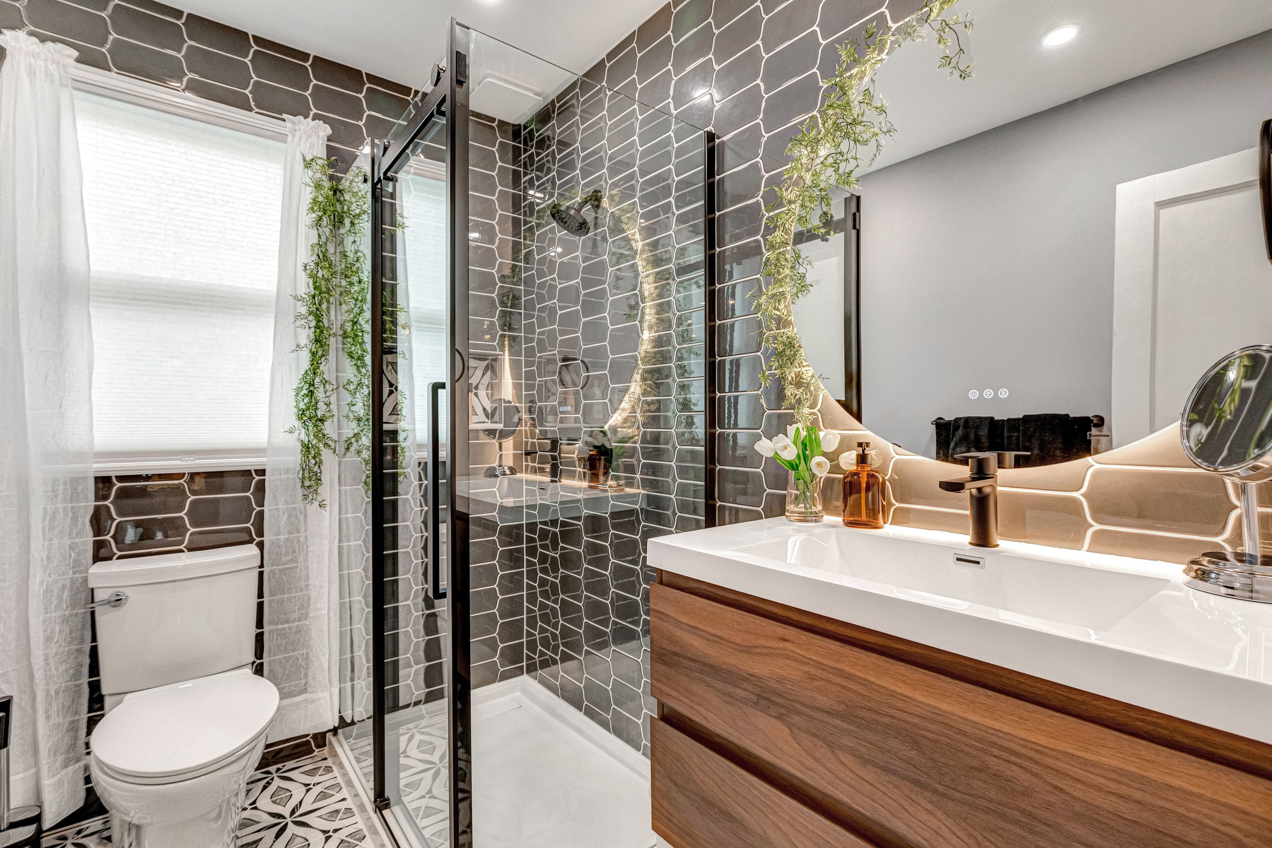 Fully renovated bathroom with glass shower and custom tile, spotless and beautifully finished.