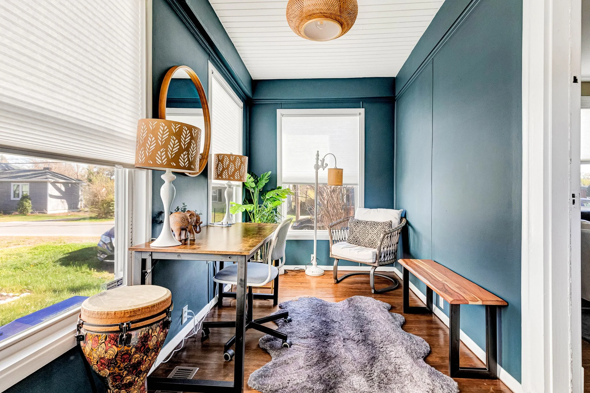 Bohemian-inspired bonus room with rich teal walls and warm lighting, a quiet space for work, relaxing, or creative hobbies.