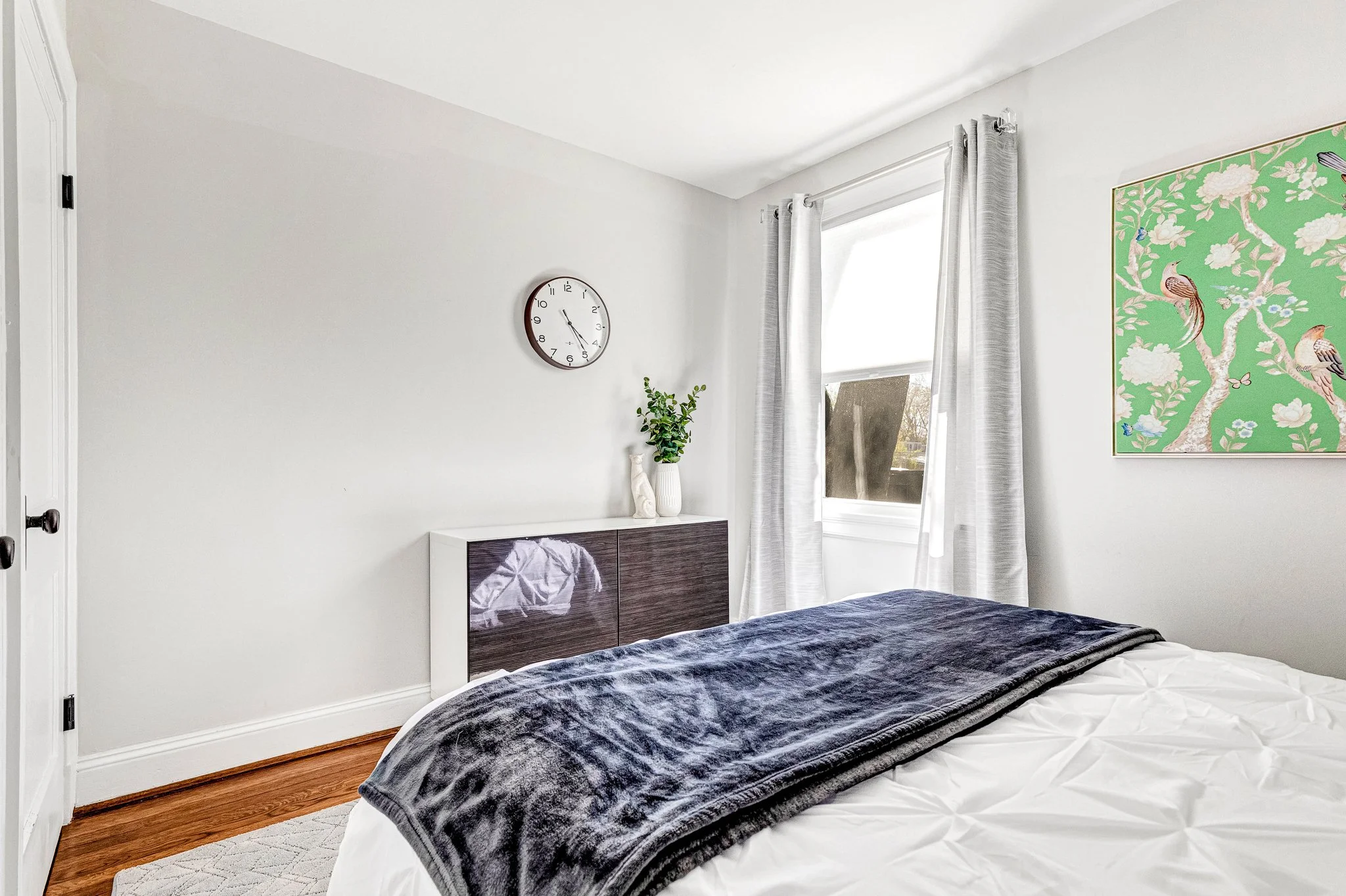 Queen bedroom with blackout curtains and clothing storage, perfect for extended stays.