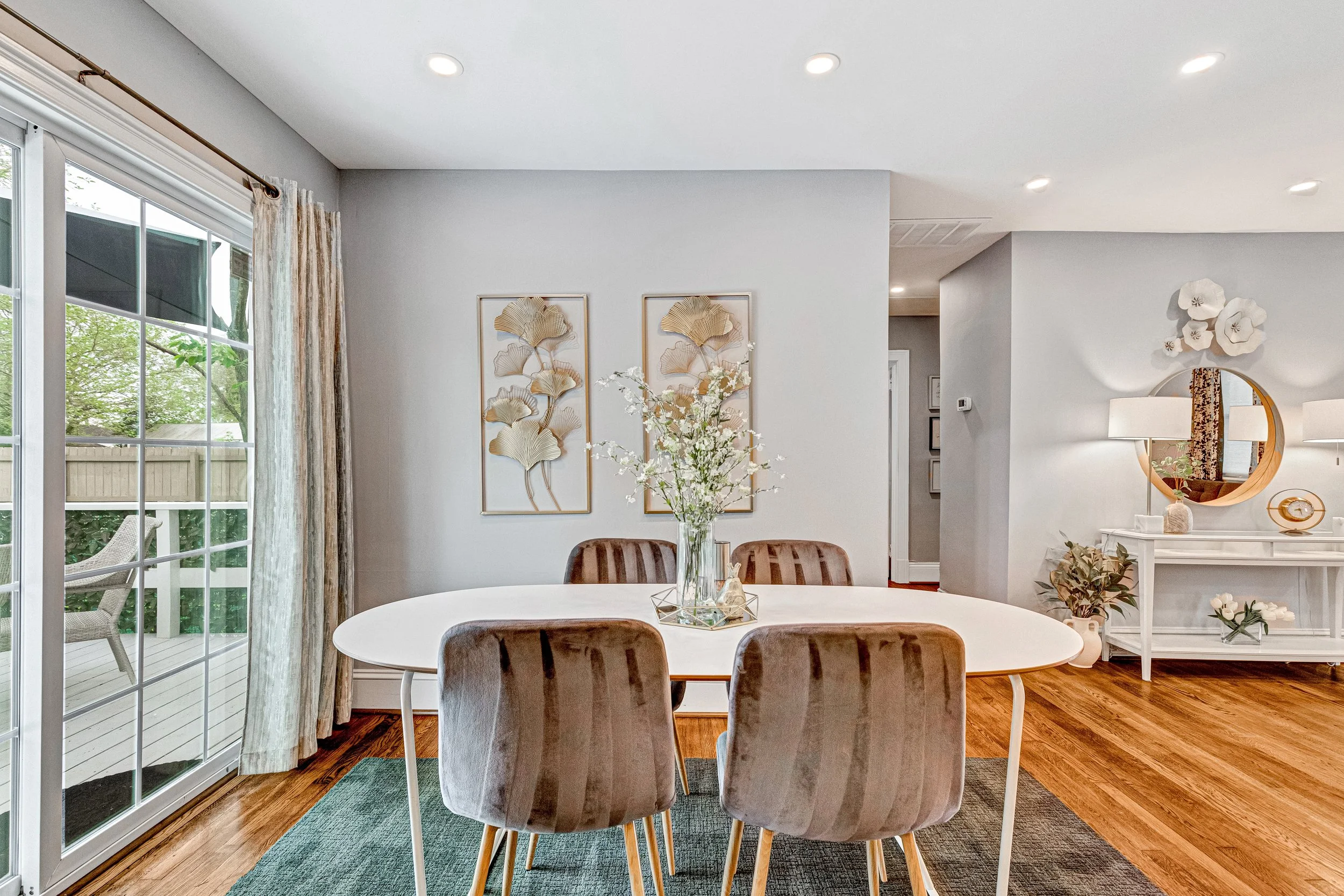 Gather in the dining area with elegant gold accents and plenty of natural light from the sliding doors.