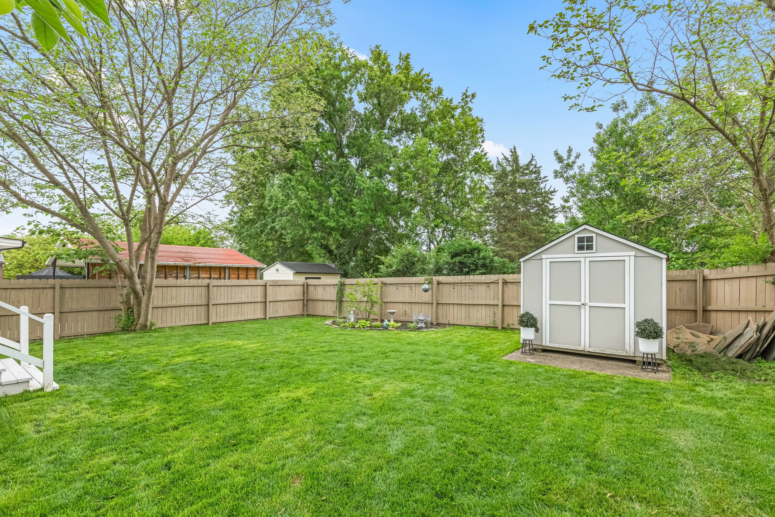 Large backyard with fresh green grass, excellent for spending time outdoors together. 