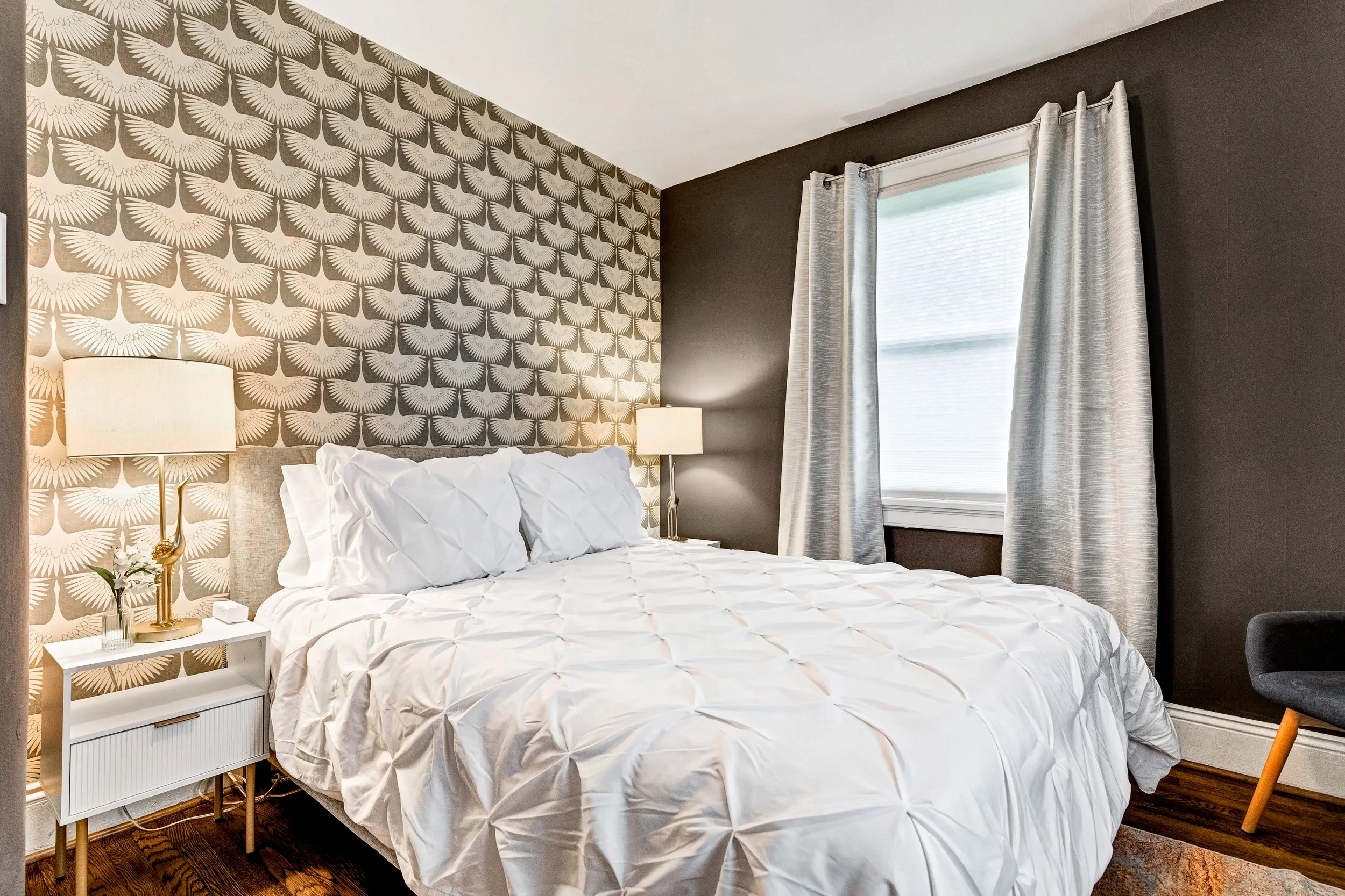 The silver bedroom with luxury bedding, stylish decor and blackout curtains. 