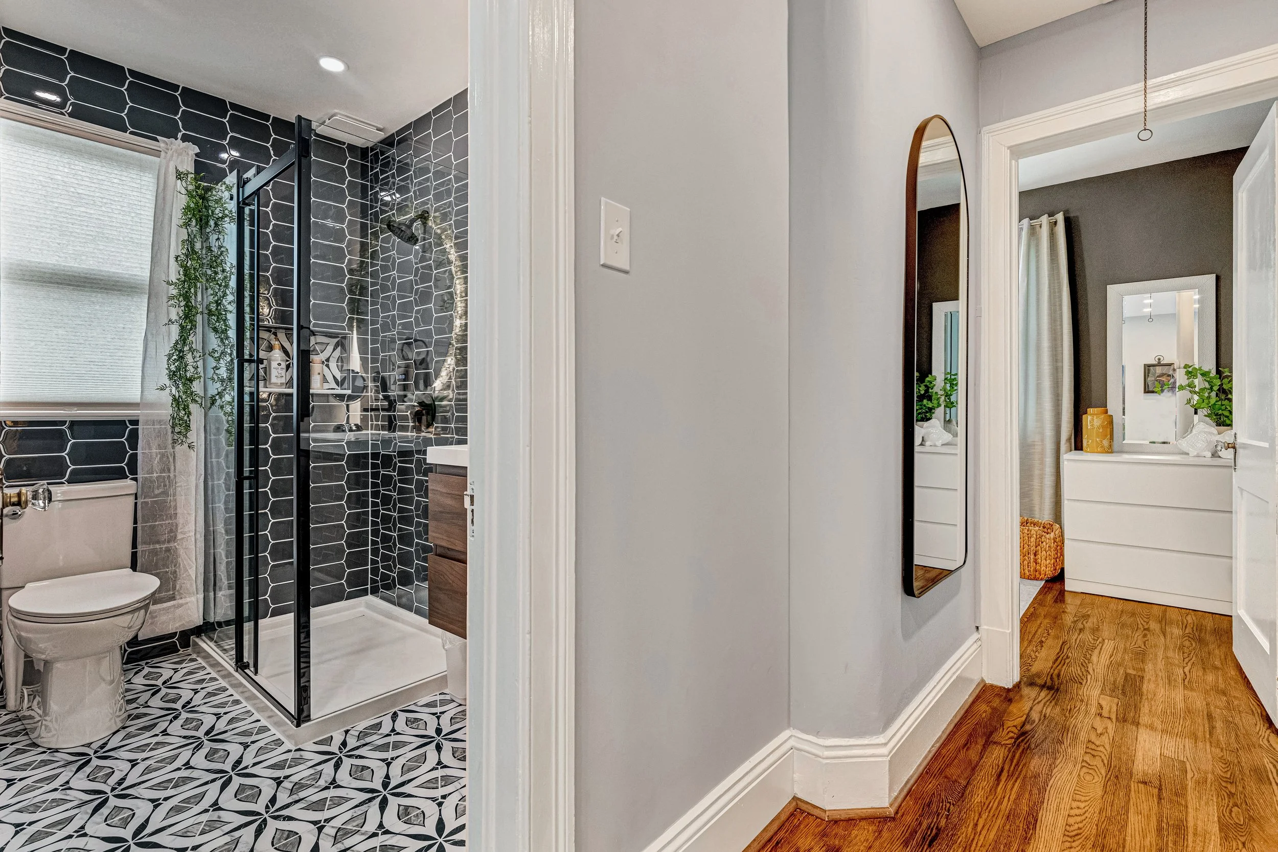 The hallway leads to the silver bedroom with a large mirror and dresser for clothing storage. 
