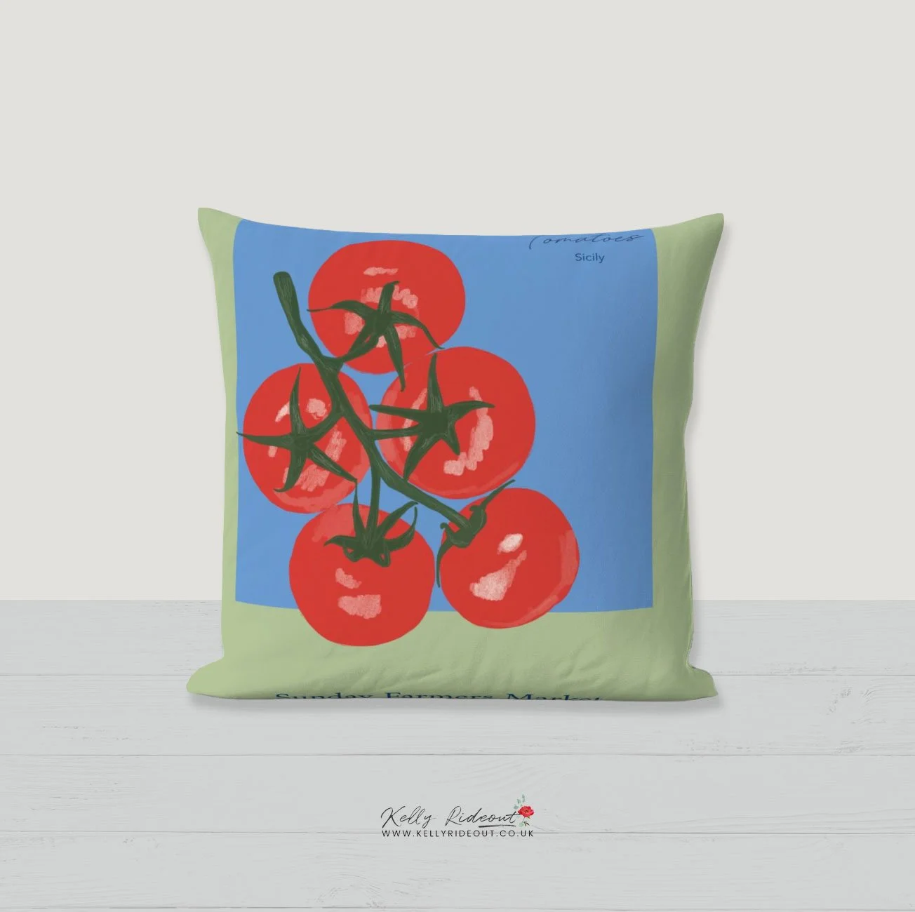 Decorative pillow featuring a colorful illustration of a bunch of red tomatoes on a vine with a blue background and green borders. Example of Kelly Rideout's patterns for licensing  on a garden cushion