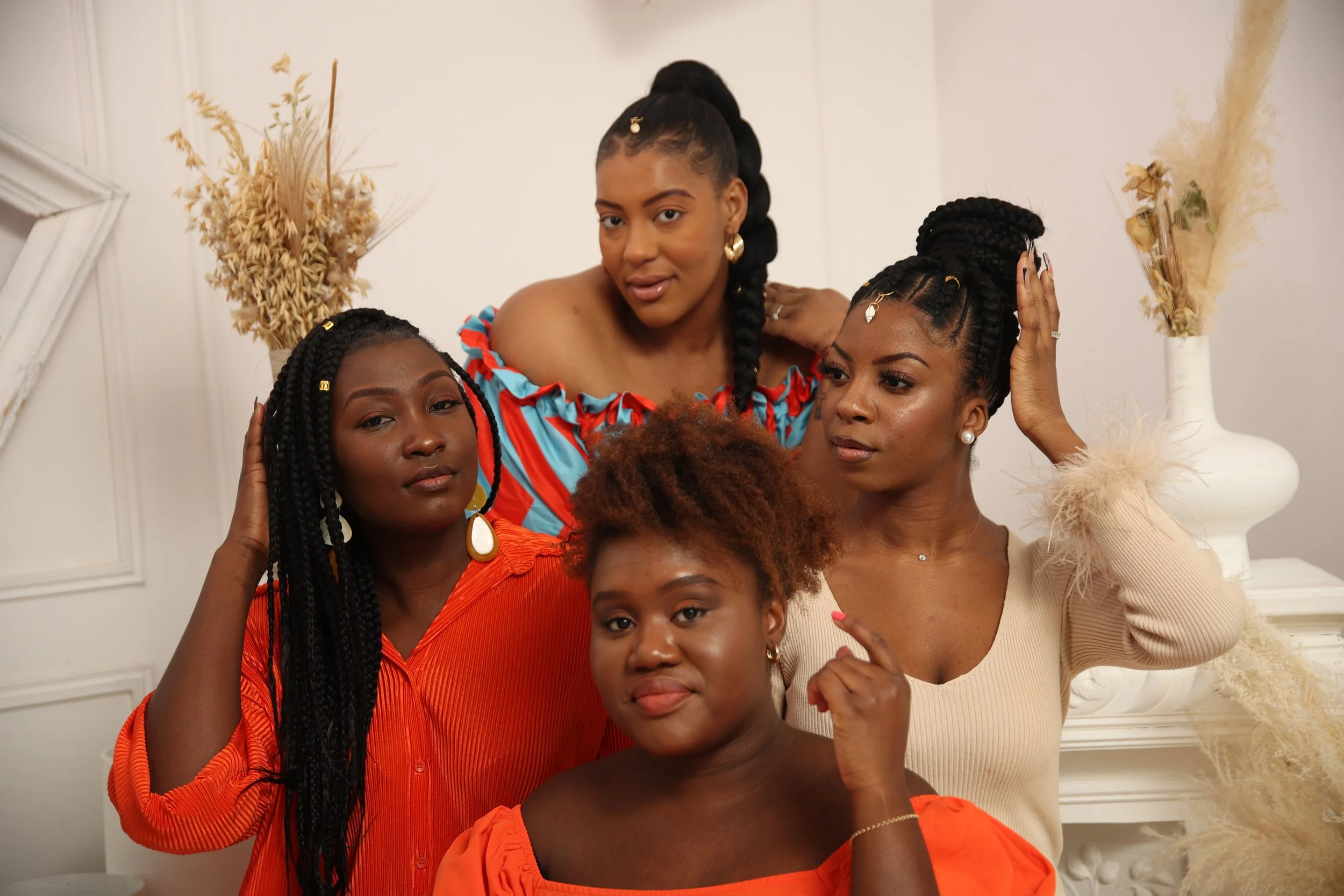 4 femmes africaines avec tresses africaines fait par la coiffeuse afro Lonnaise. vétements orange, tresses avec des extensions, tresses avec des méches, tresses avec des rajouts, tresses sur cheveux crépus et longs, tresses sur cheveux crépus cours