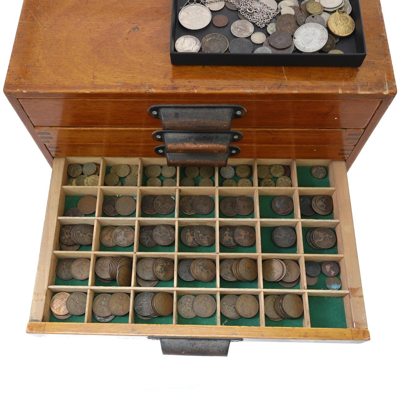 Vintage coin collection displayed in a wooden compartment tray and coin album.