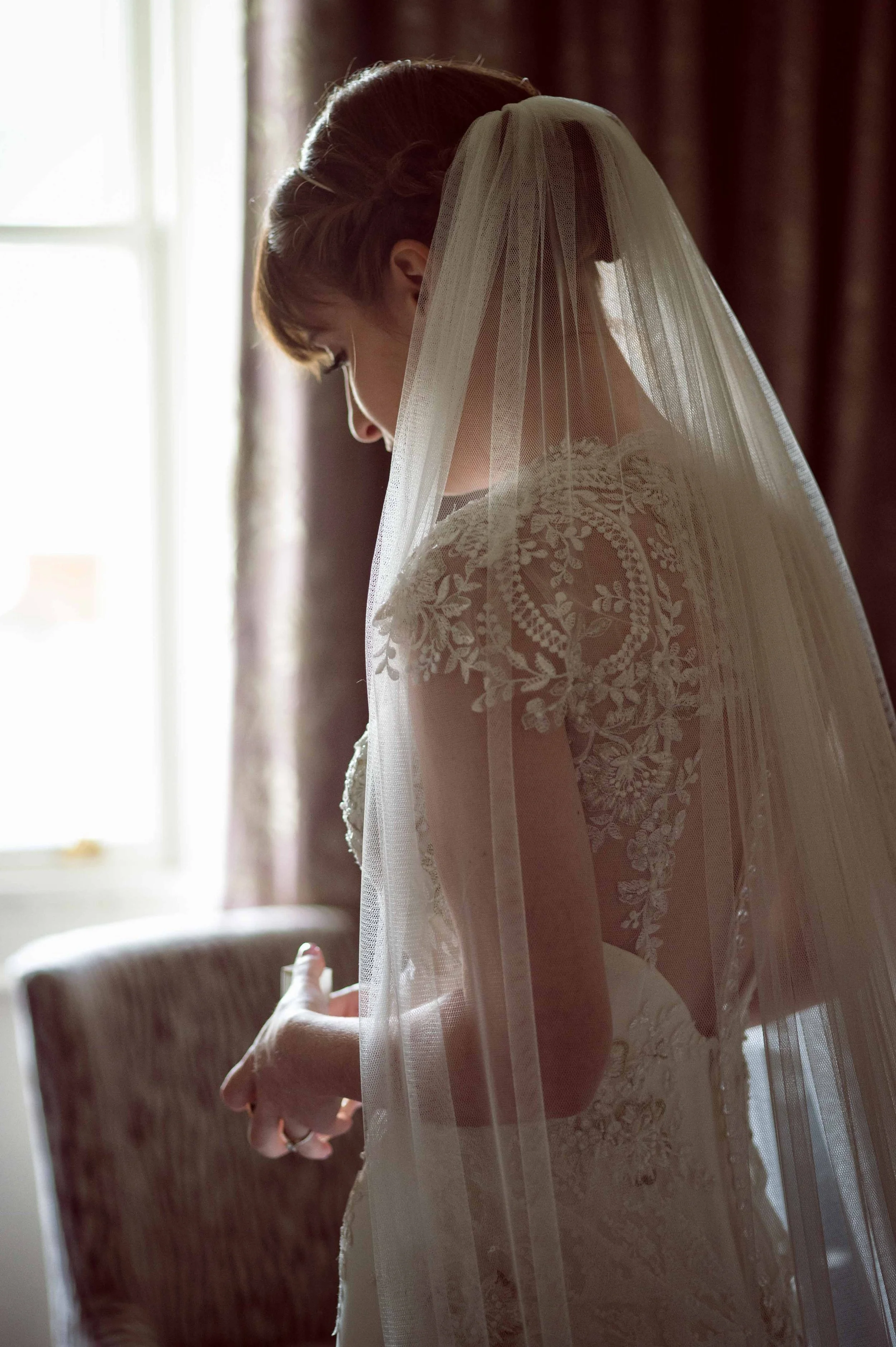 Backlit portrait bride deep in thought before ceremony