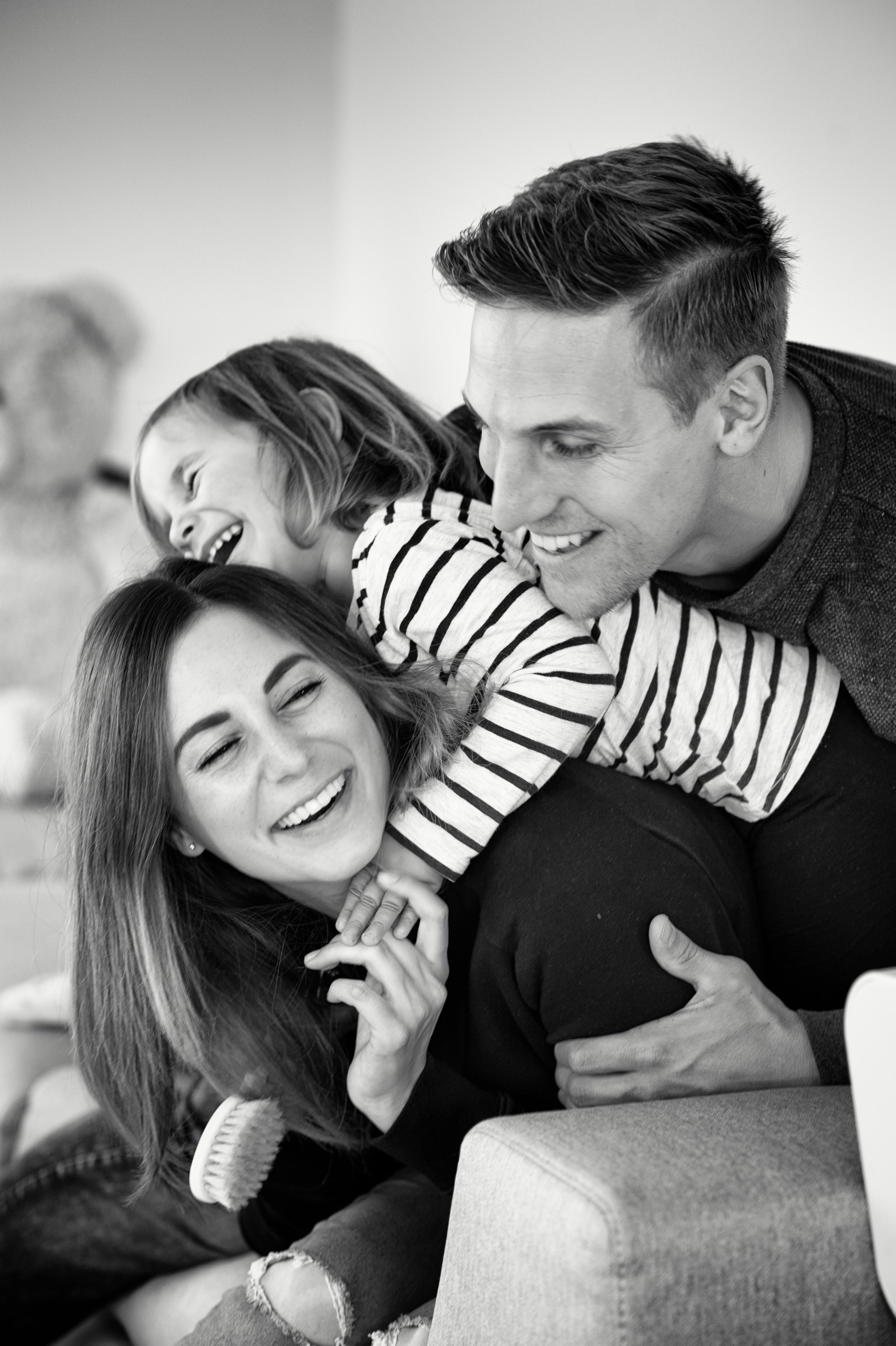 Black and white family portrait laughing and cuddling