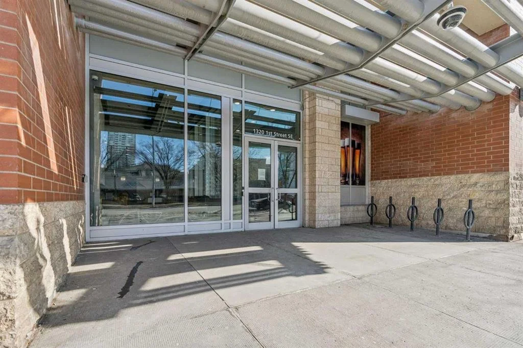 Store entrance with glass sliding doors, bike racks, and a partially visible sign above the door.