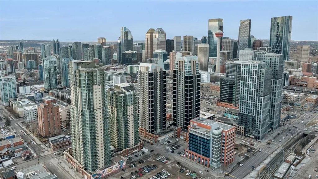 A city skyline with tall modern skyscrapers, including office buildings and residential towers, under a clear sky.