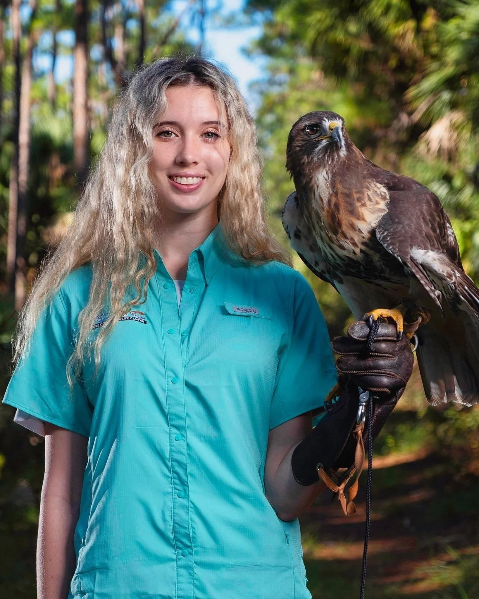 Outdoor portrait of a woman holding a bird of prey, photographed by Paul Piasecki.