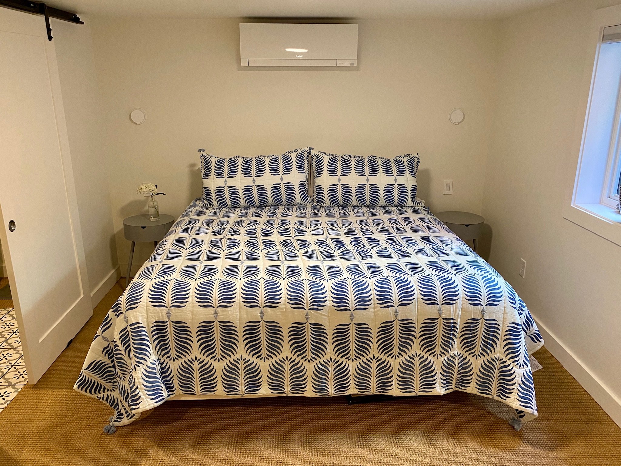 Bedroom with navy and cream patterned bedspread and hardwood flooring — Magnolia, Seattle full home remodel