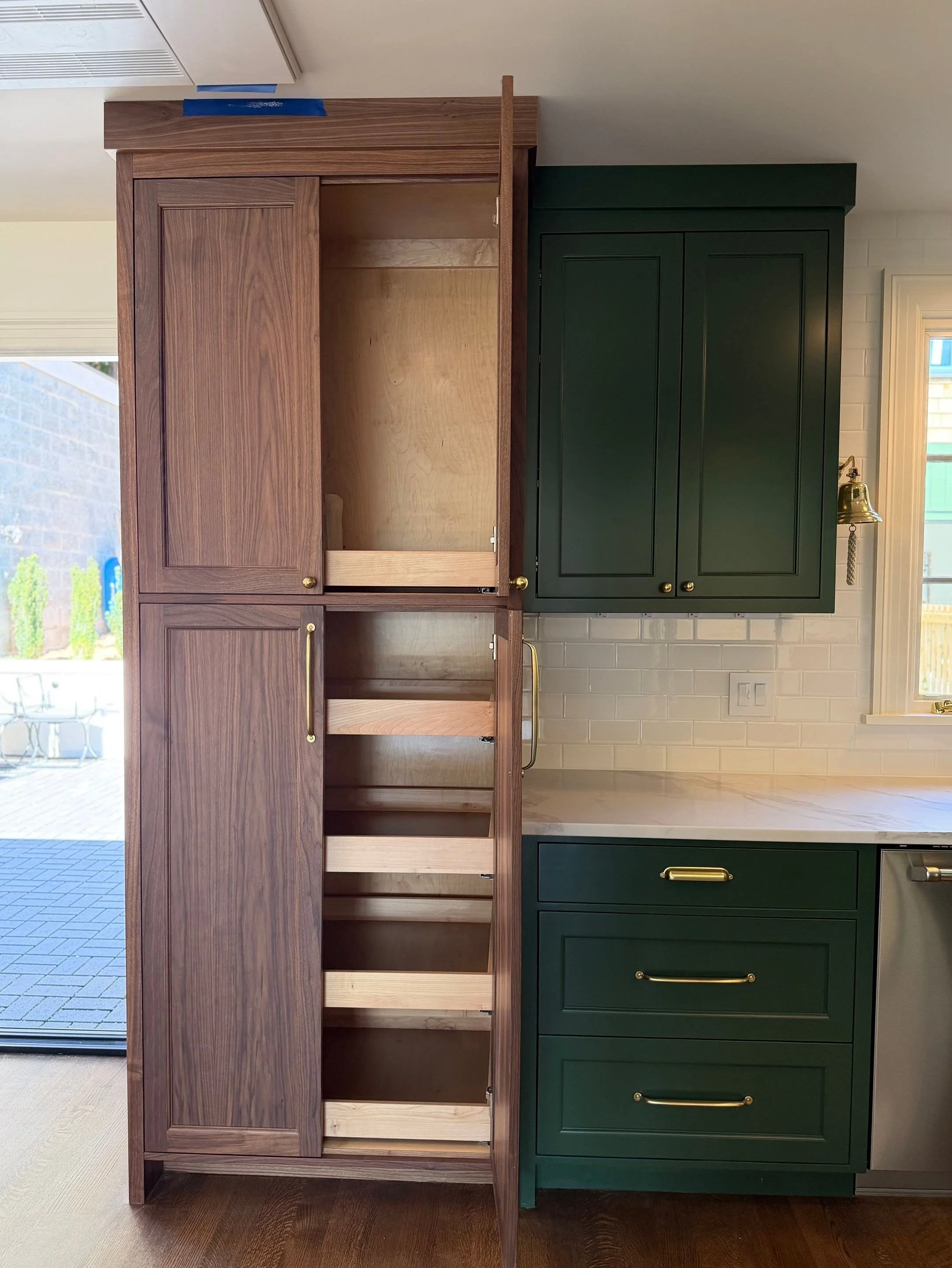 Built-in closet system with wood shelving, pull-out drawers, and green cabinetry — Discovery Park, Seattle whole-home addition