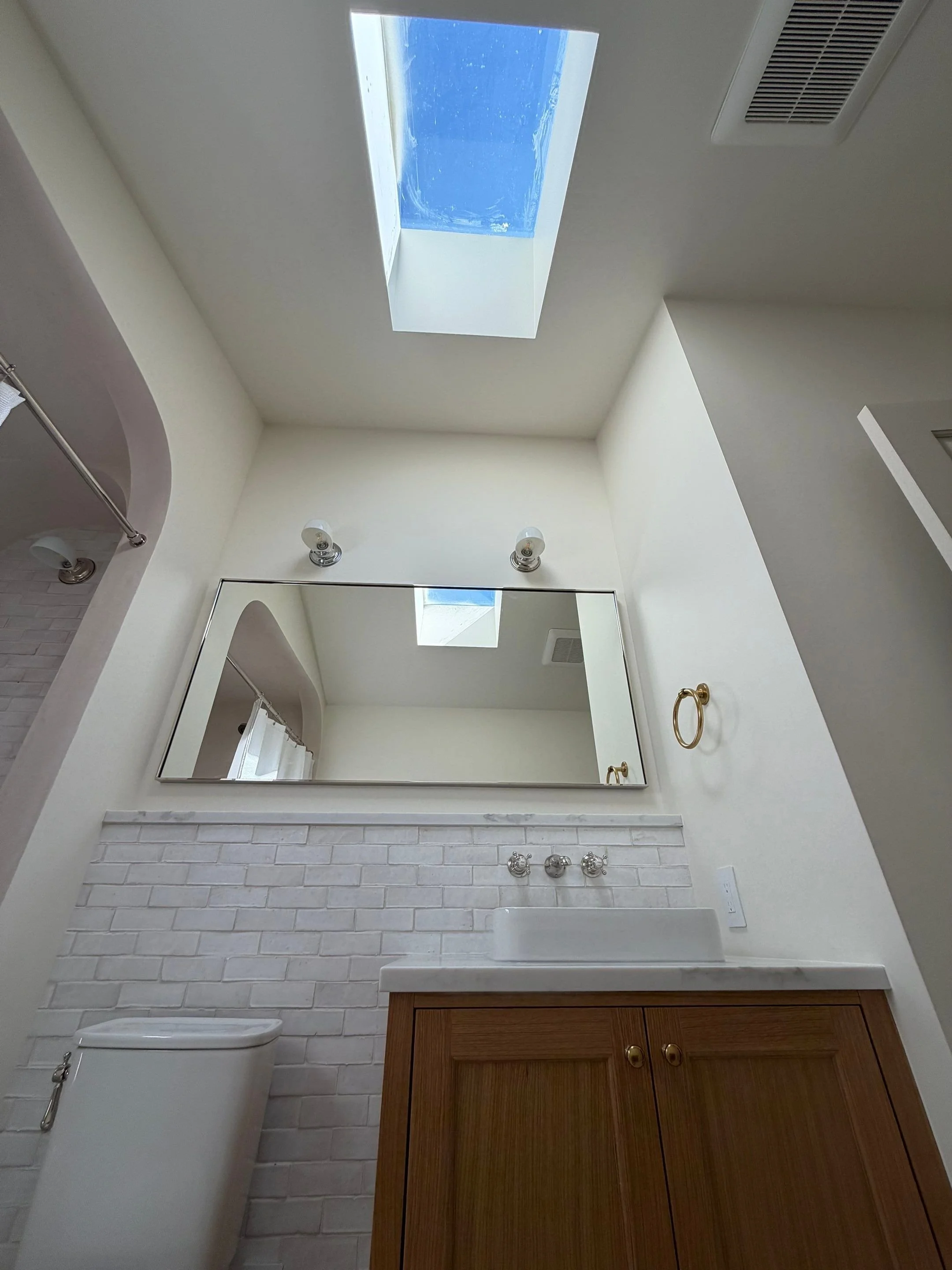 Bathroom with skylight, white subway tile, and wood vanity — Discovery Park, Seattle whole-home addition
