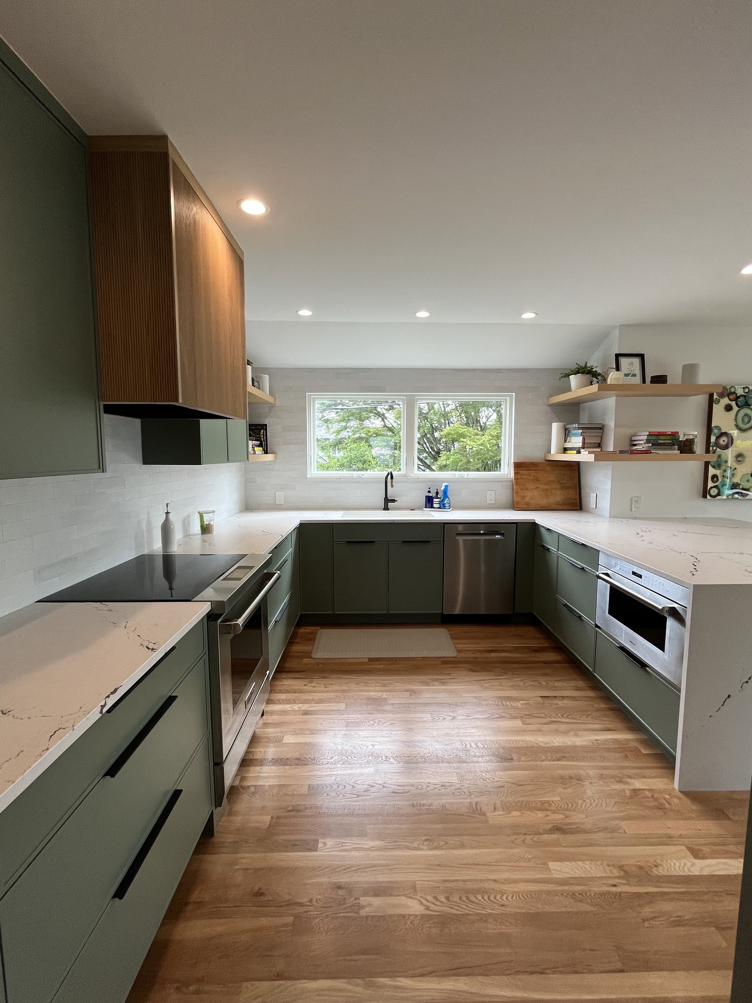 Kitchen with sage green cabinetry, wood range hood, and hardwood flooring — Wallingford, Seattle kitchen and bath remodel