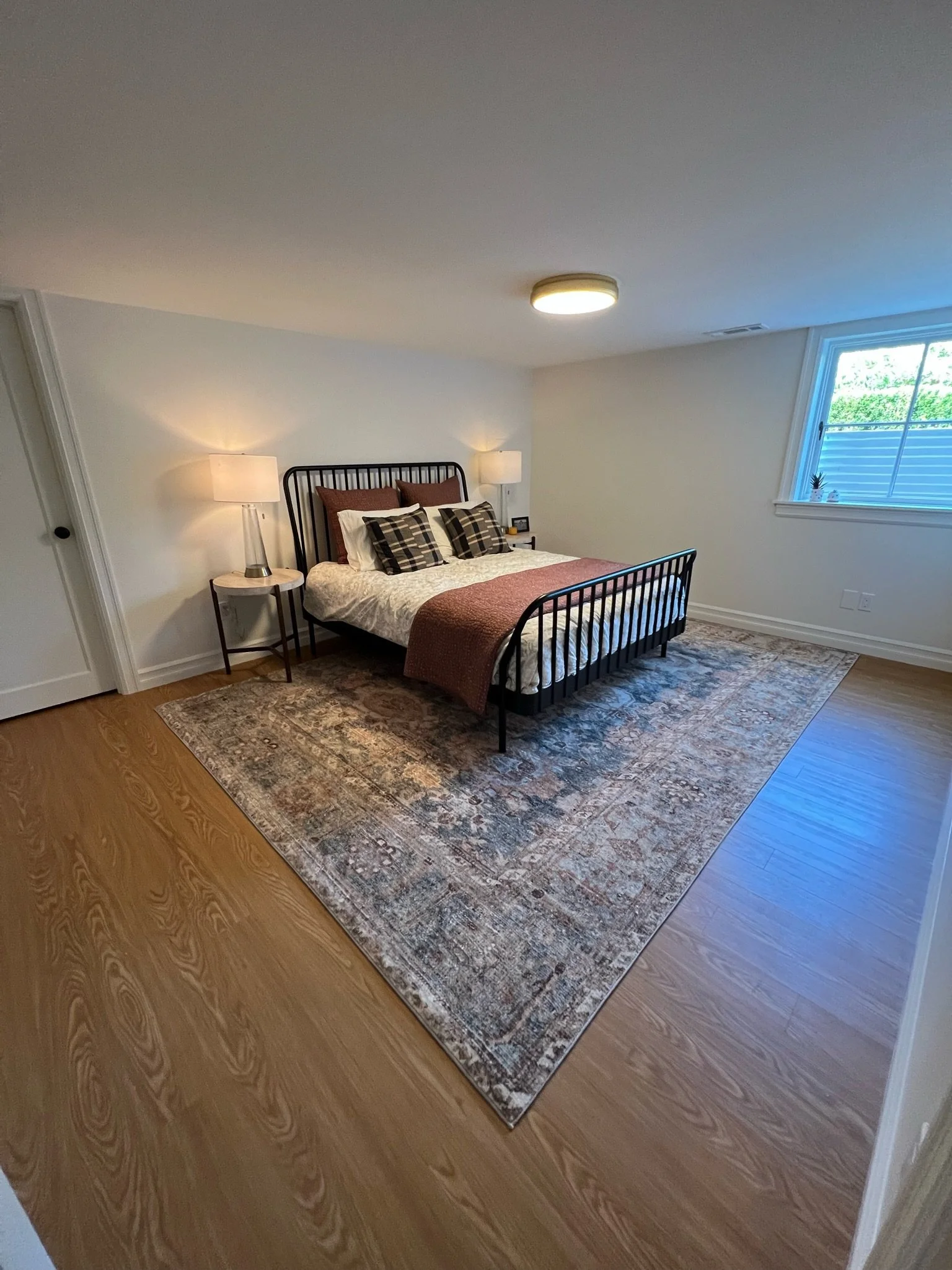 Bedroom with dark wood bed frame and area rug — Magnolia, Seattle full home remodel