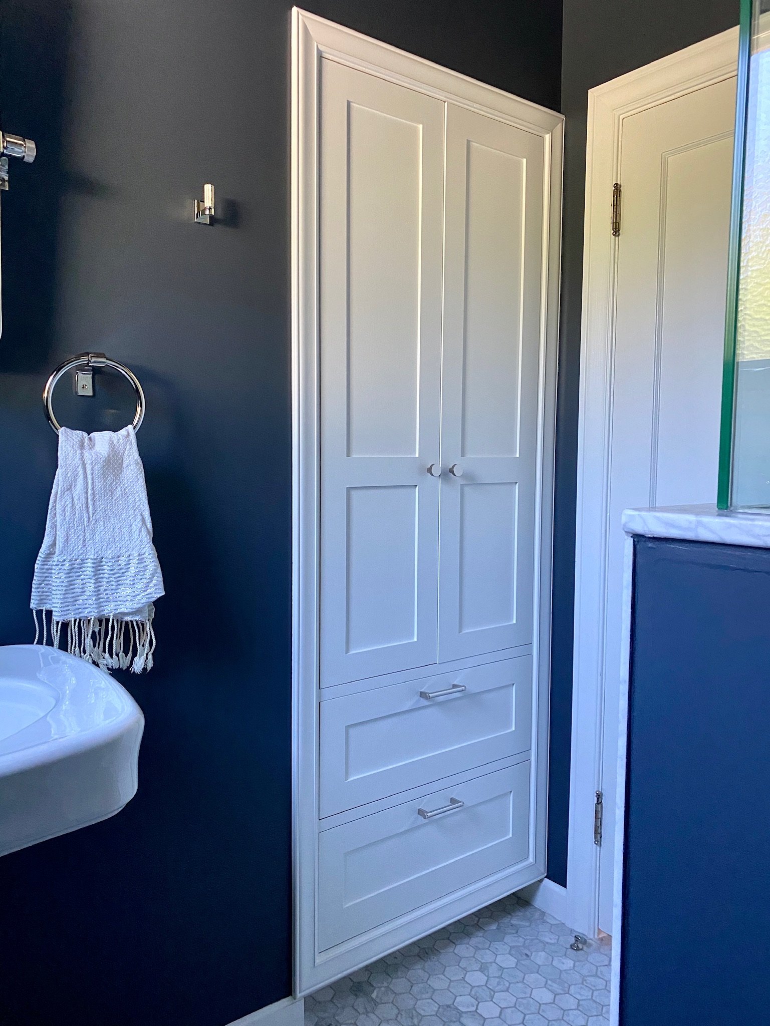 Bathroom with navy walls, toilet, and built-in white linen cabinet — Magnolia, Seattle full home remodel
