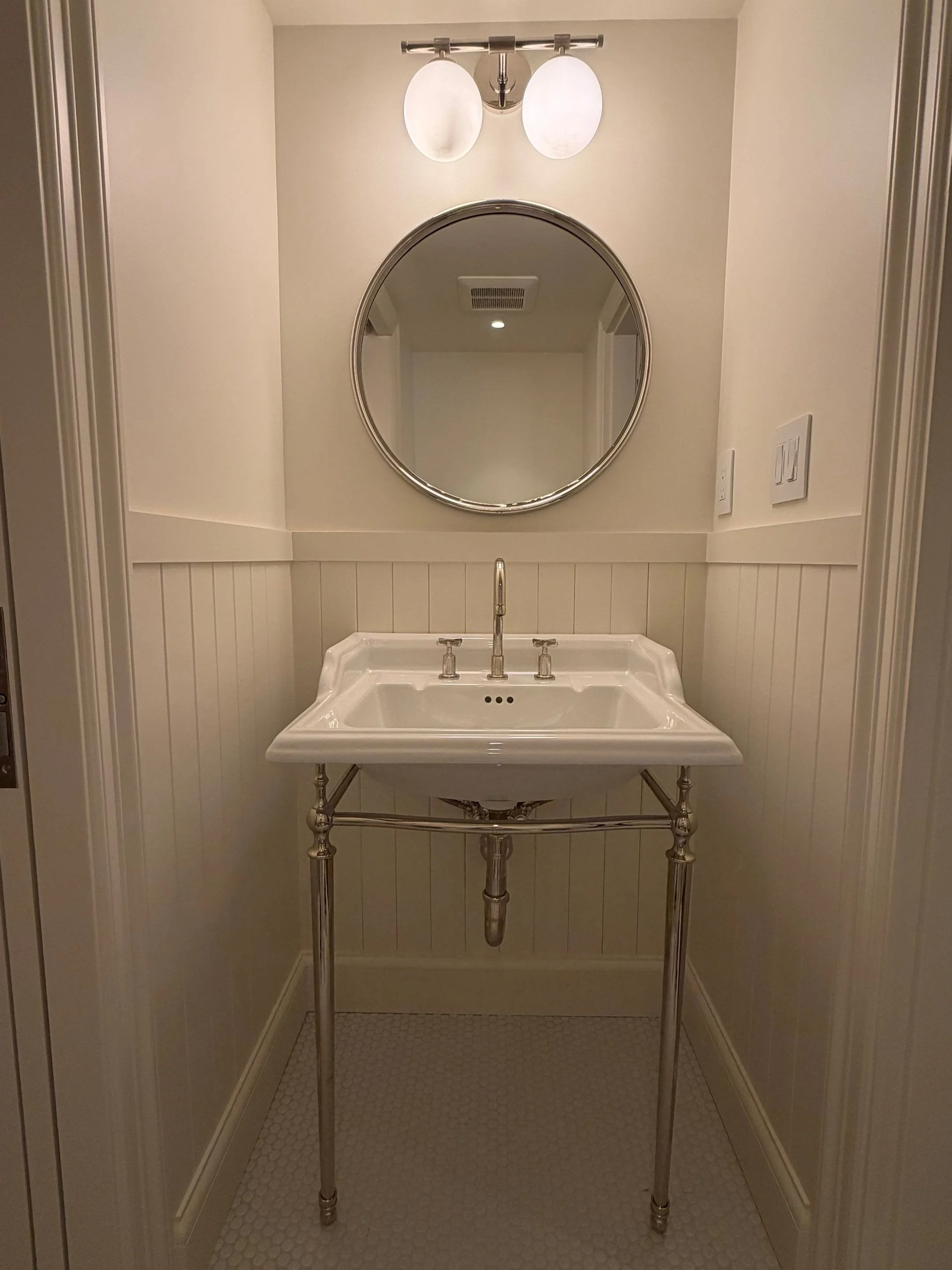 Powder room with console sink and round mirror — Discovery Park, Seattle whole-home addition