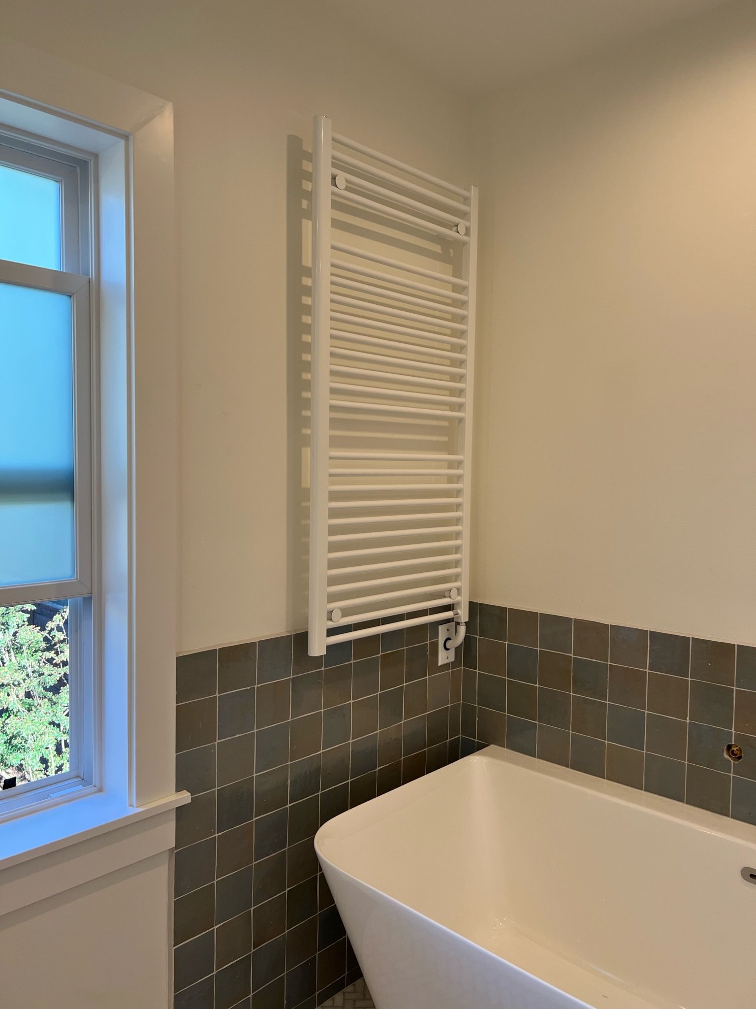 Bathroom window nook with heated towel rack and blue subway tile above the soaking tub — Viewmont, Seattle primary bath remodel