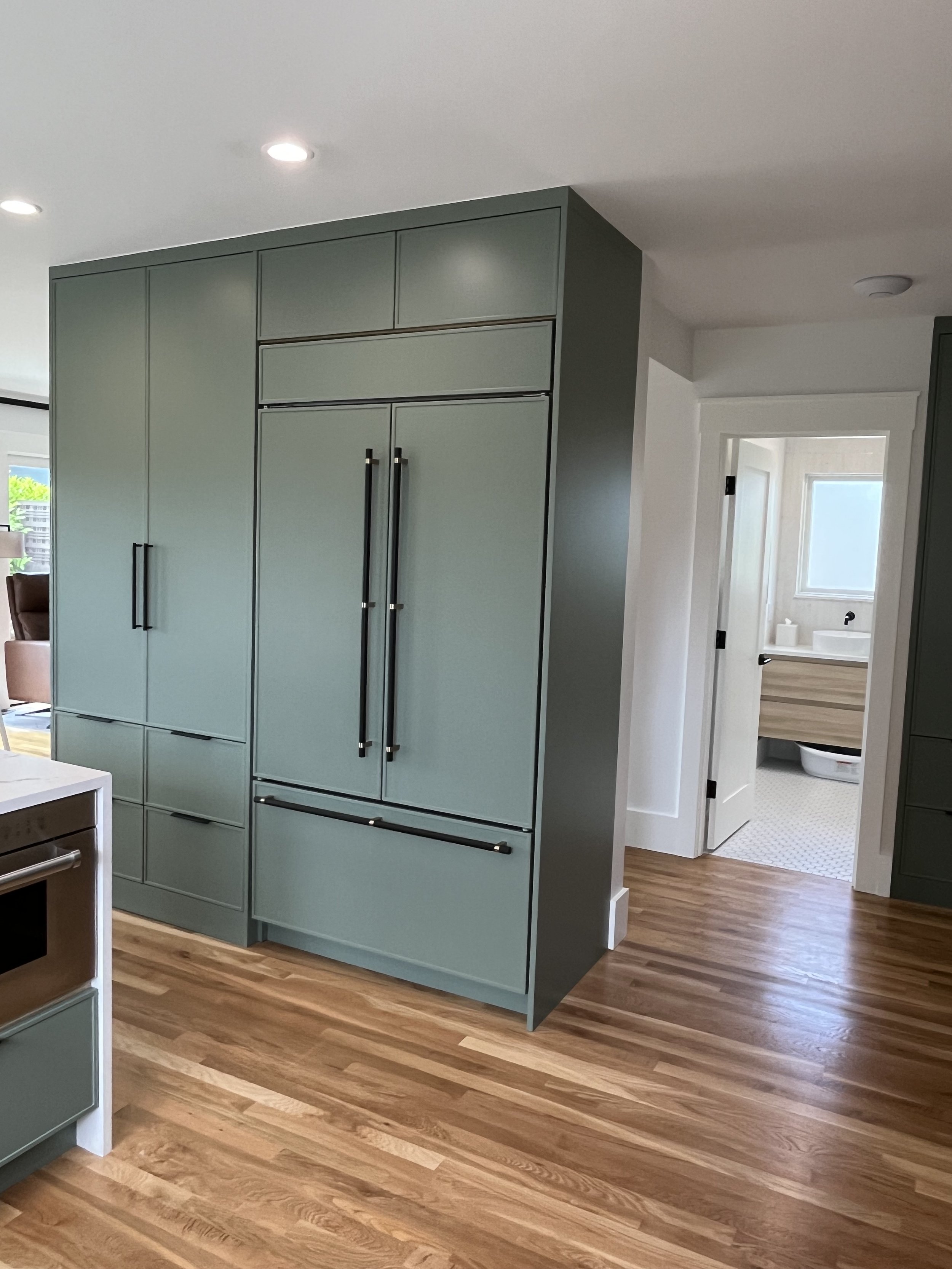 Paneled refrigerator integrated into sage green cabinetry — Wallingford, Seattle kitchen and bath remodel
