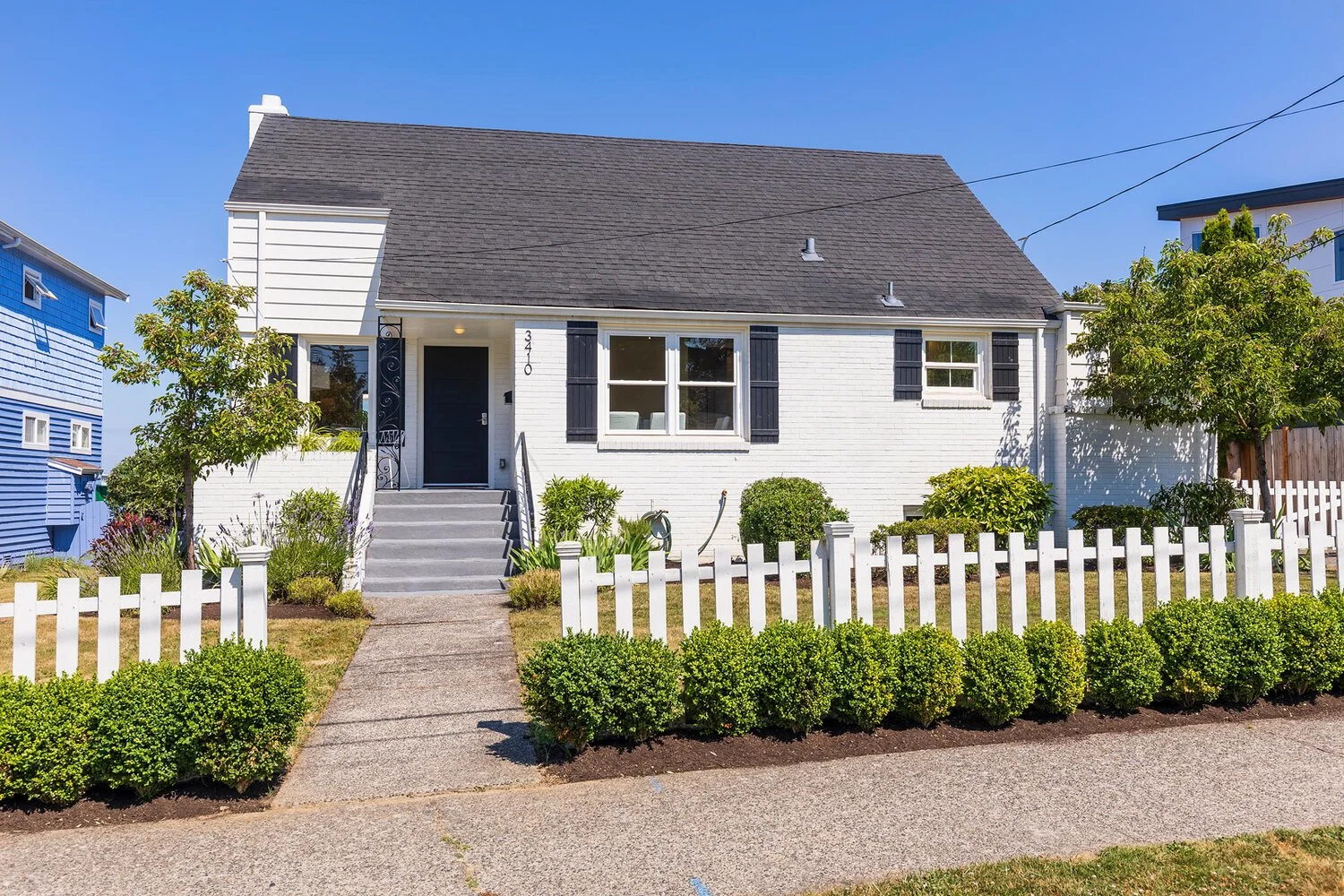 White cape cod home exterior with picket fence — Magnolia, Seattle full home remodel