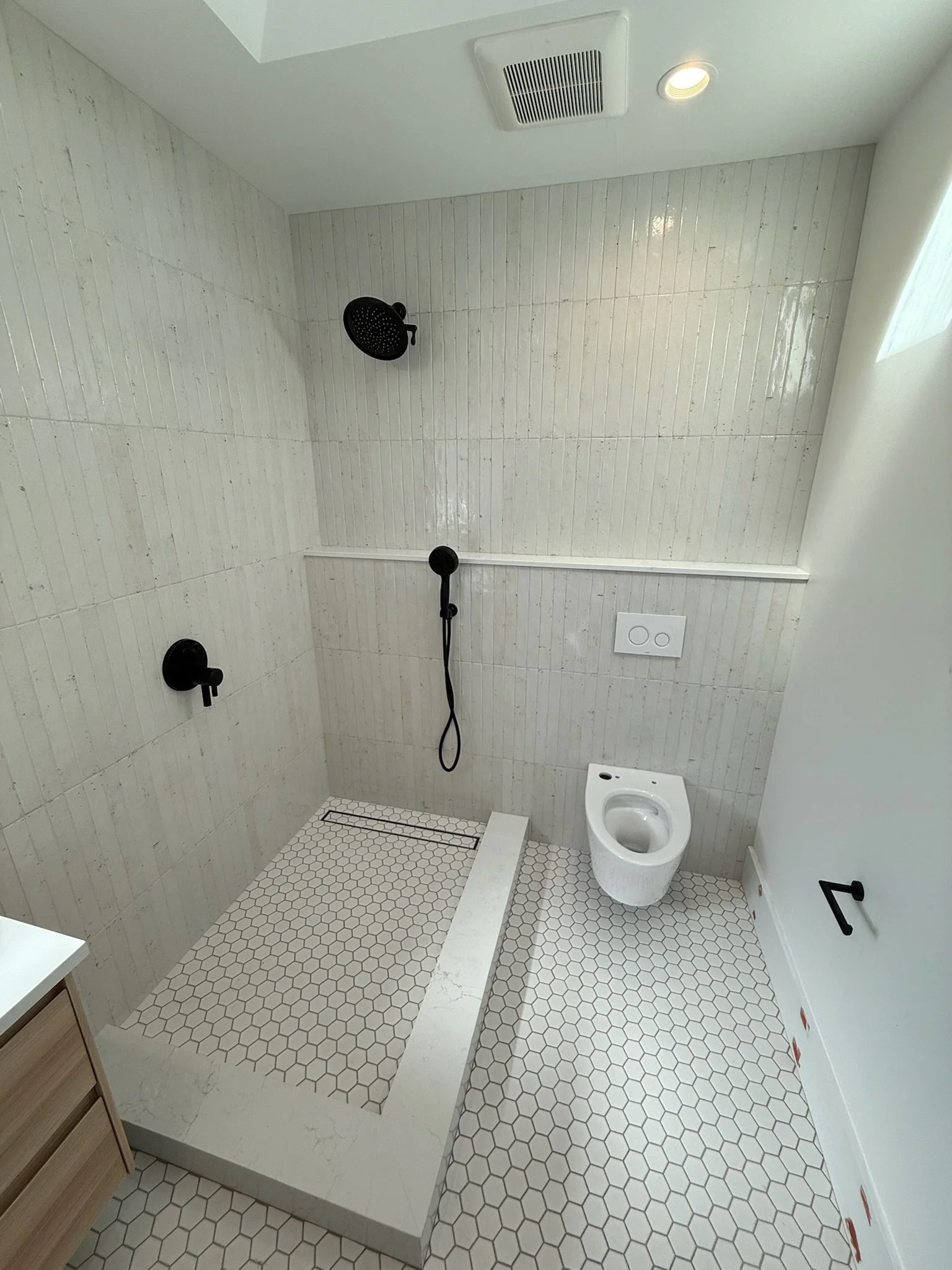 Bathroom with speckled terrazzo-style tile, toilet, and step-up shower — Wallingford, Seattle kitchen and bath remodel