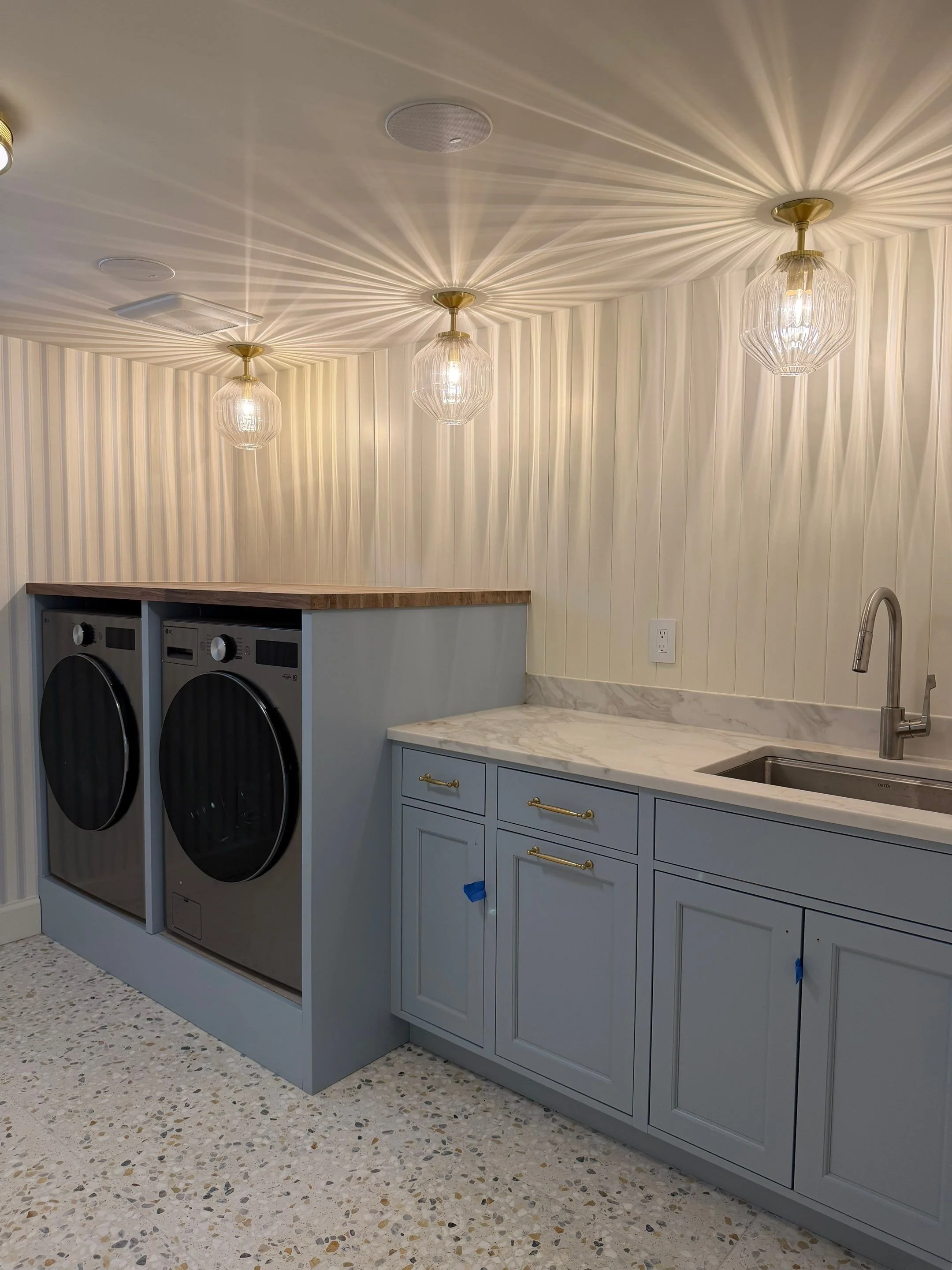 Laundry room with blue-gray cabinetry and terrazzo flooring — Discovery Park, Seattle whole-home addition