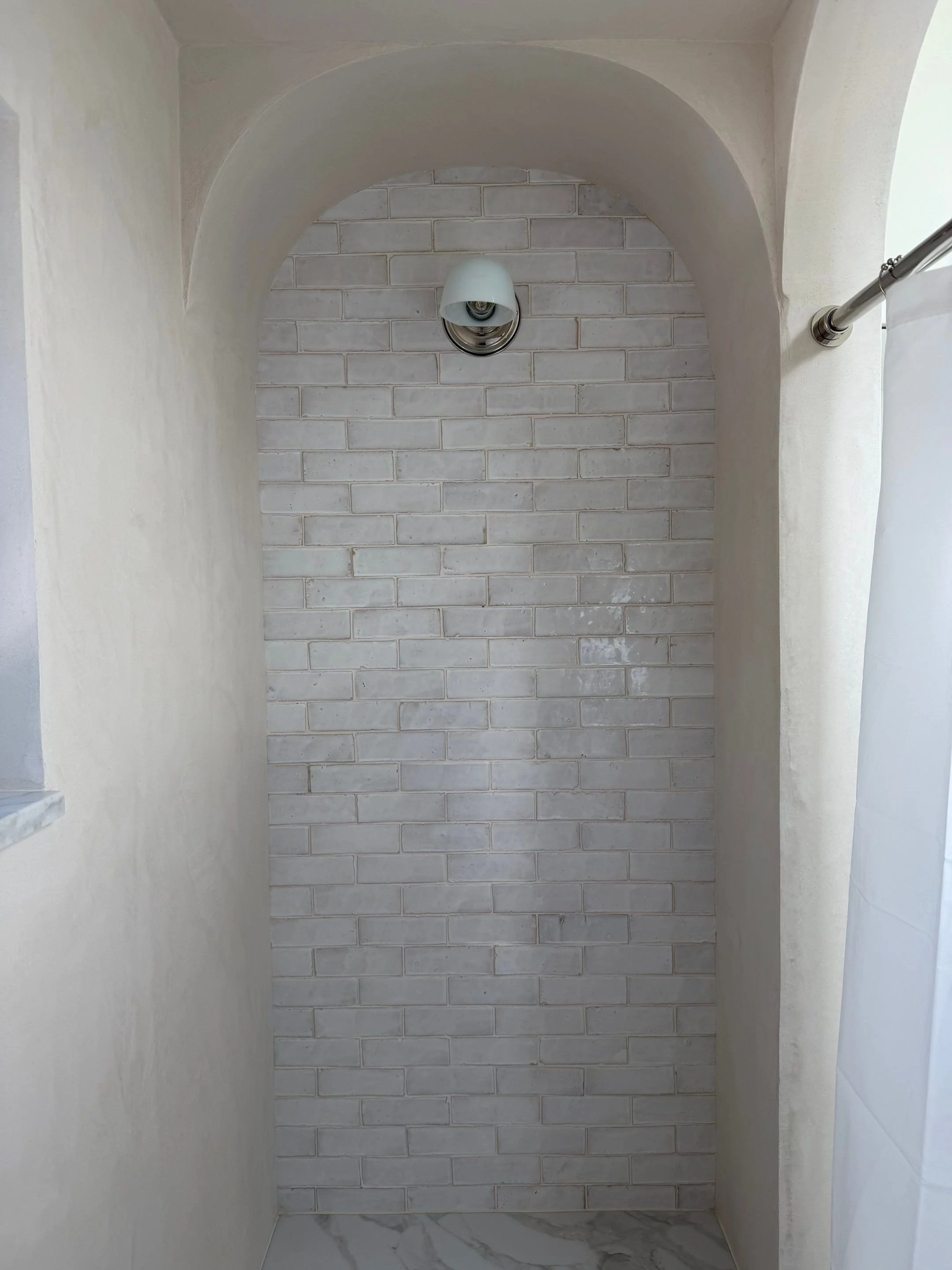 Arched hallway with white stone-tile walls — Discovery Park, Seattle whole-home addition