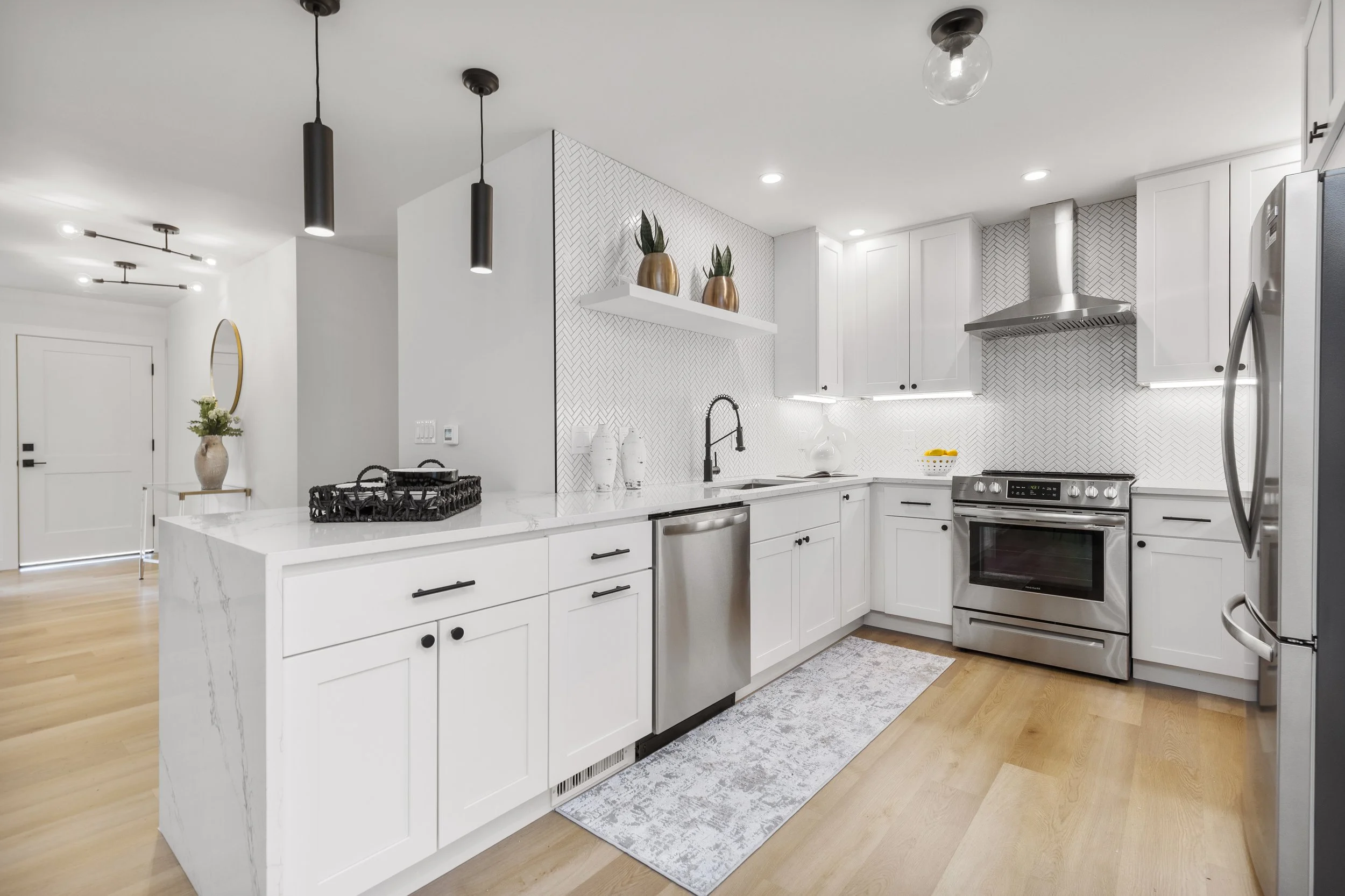 White kitchen with professional-style range, matte black hardware, and terrazzo-style flooring — Bothell, Seattle full home remodel