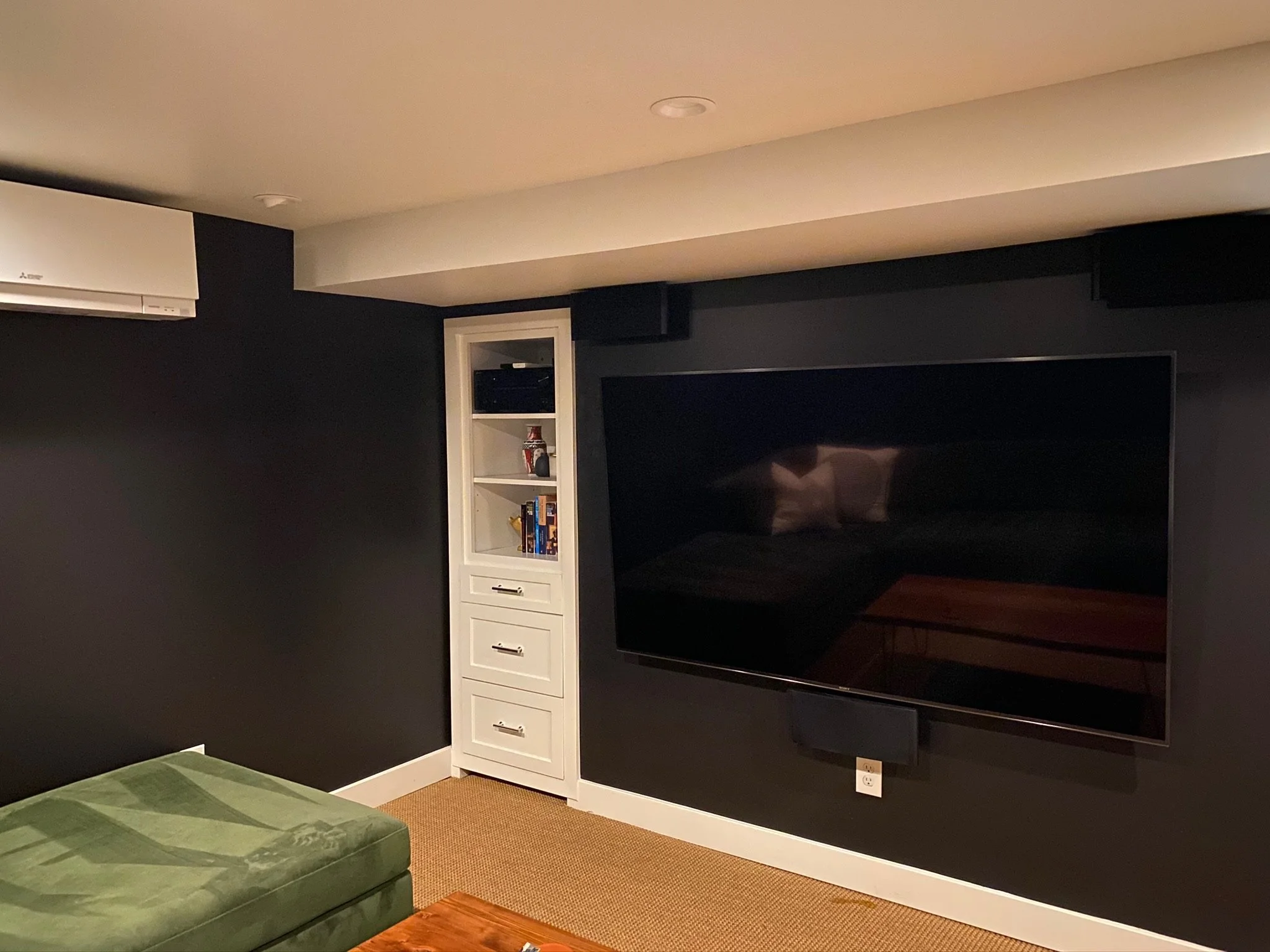 Media room with dark walls, built-in shelving, and wall-mounted television — Magnolia, Seattle full home remodel