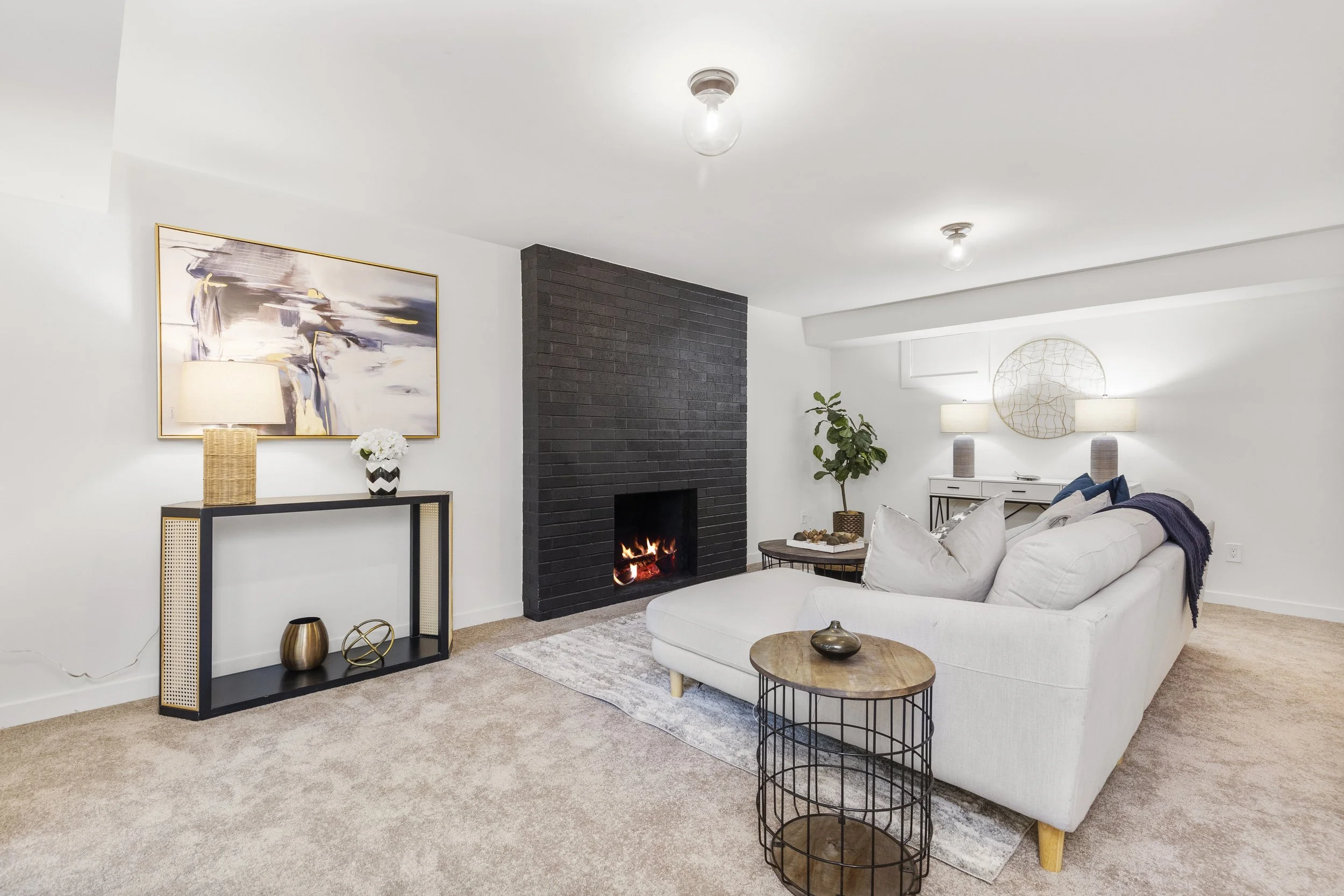 Living room view with black brick fireplace, console table, and framed art — Bothell, Seattle full home remodel