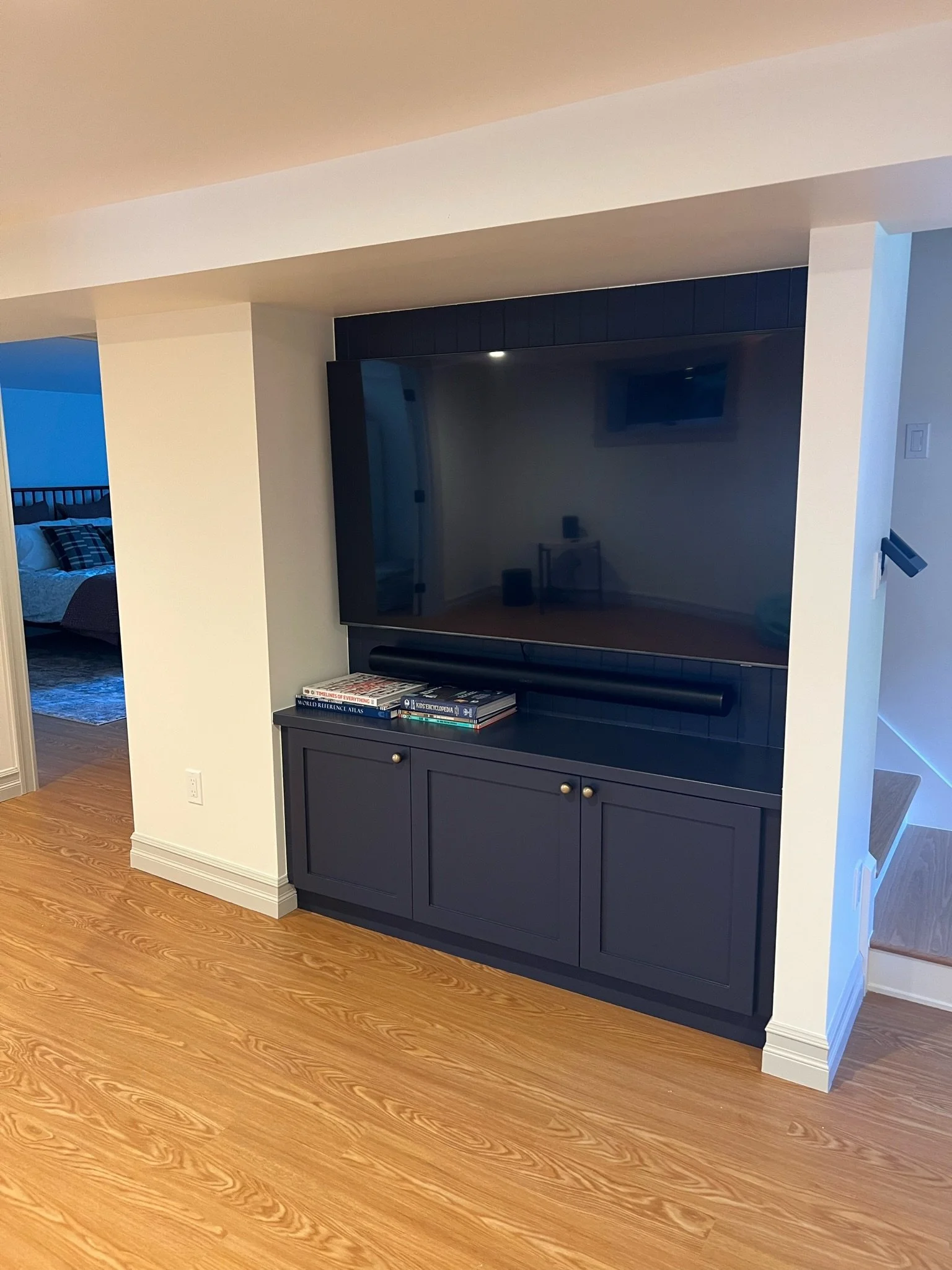 Basement media room with built-in navy cabinetry and mounted television — Magnolia, Seattle full home remodel
