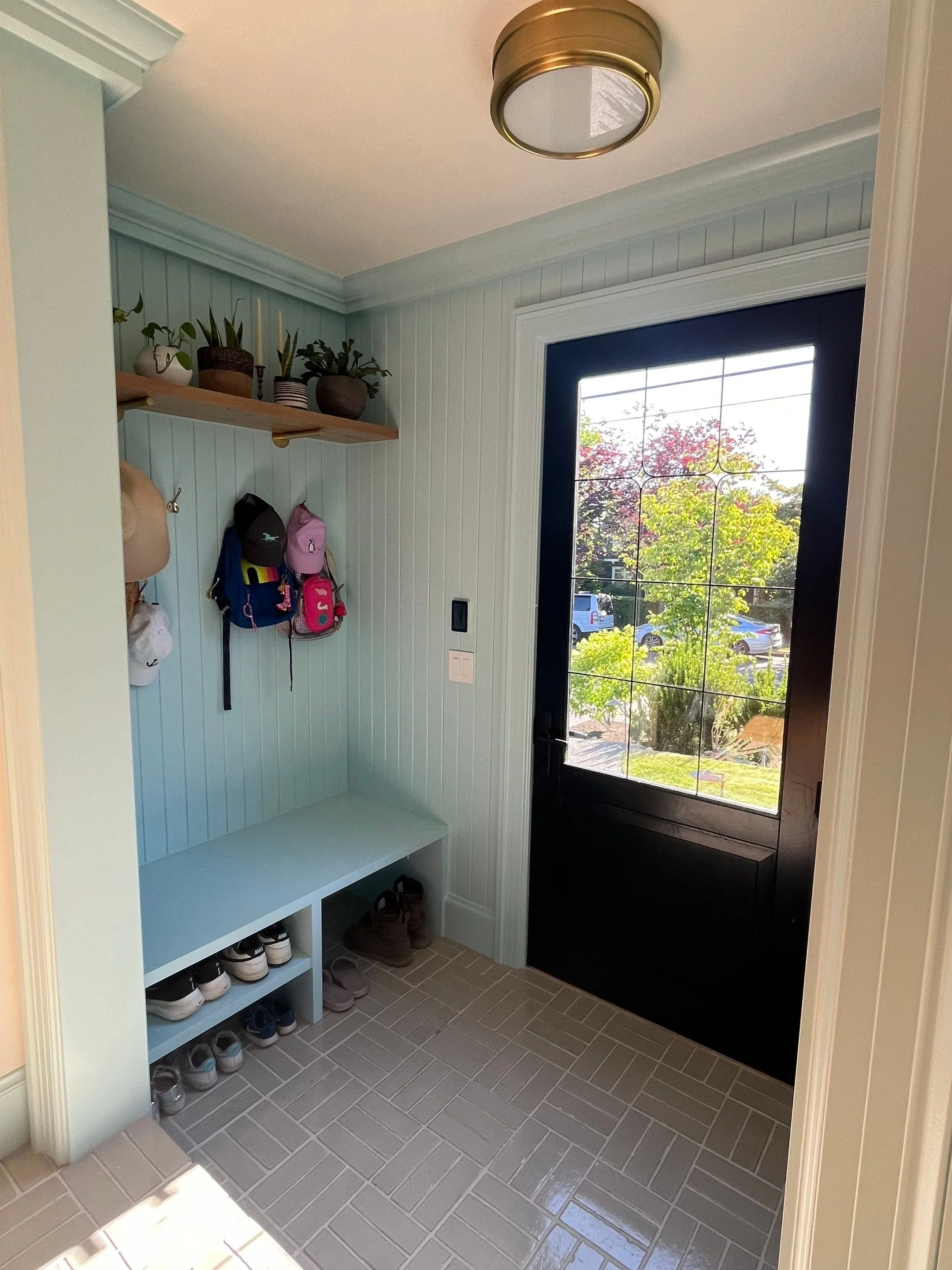 Mudroom with built-in bench and black exterior door — Magnolia, Seattle full home remodel