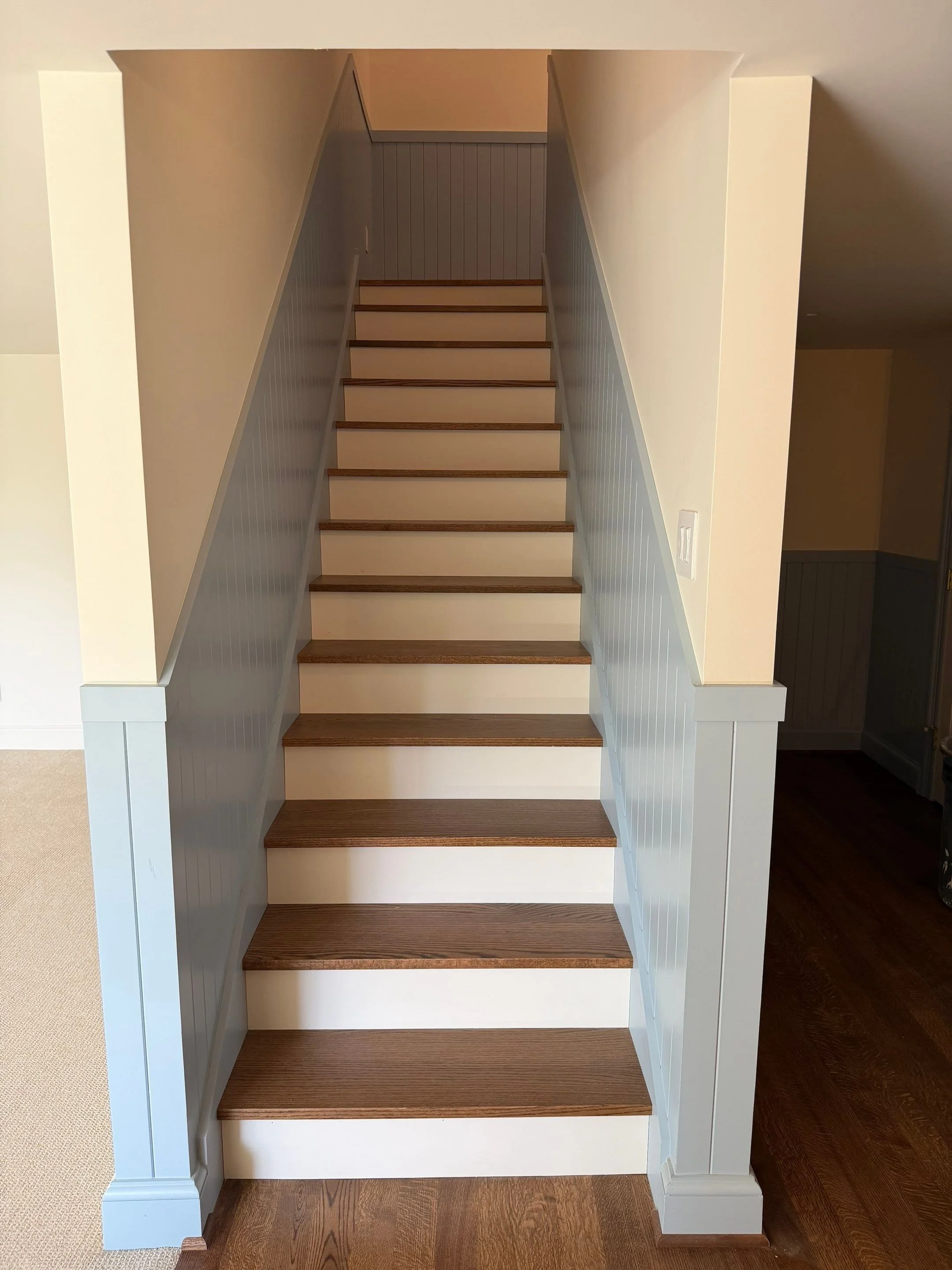 Staircase with painted blue-gray trim and wood treads — Discovery Park, Seattle whole-home addition