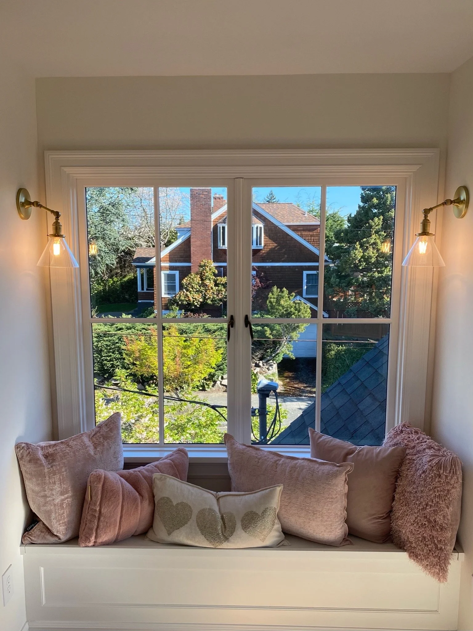 Close-up of built-in window seat with pink pillows and wall sconces — Magnolia, Seattle full home remodel
