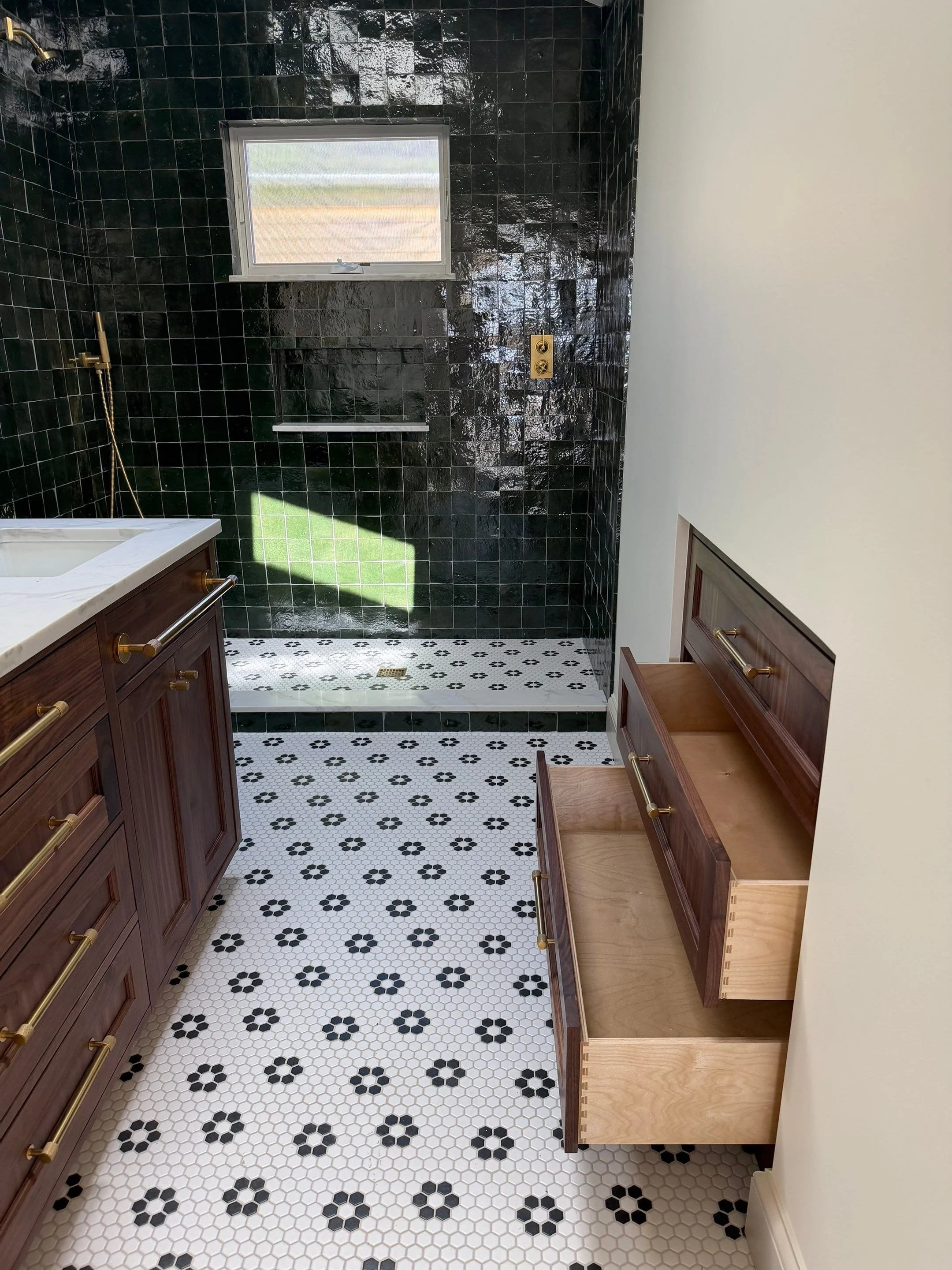 Bathroom with dark green hexagonal tile walls, patterned floor tile, and a built-in bench — Discovery Park, Seattle whole-home addition