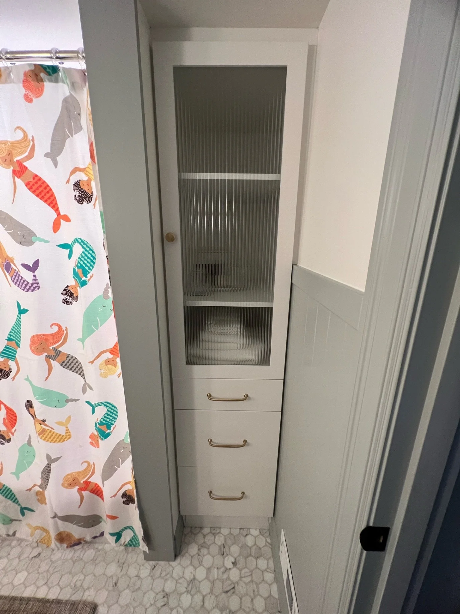 Built-in linen closet with colorful floral wallpaper backdrop — Magnolia, Seattle full home remodel
