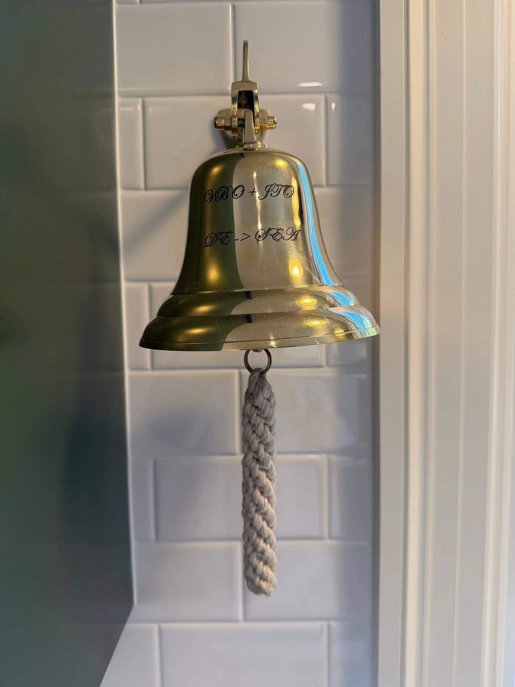 Vintage brass servant's bell mounted on tile with rope pull