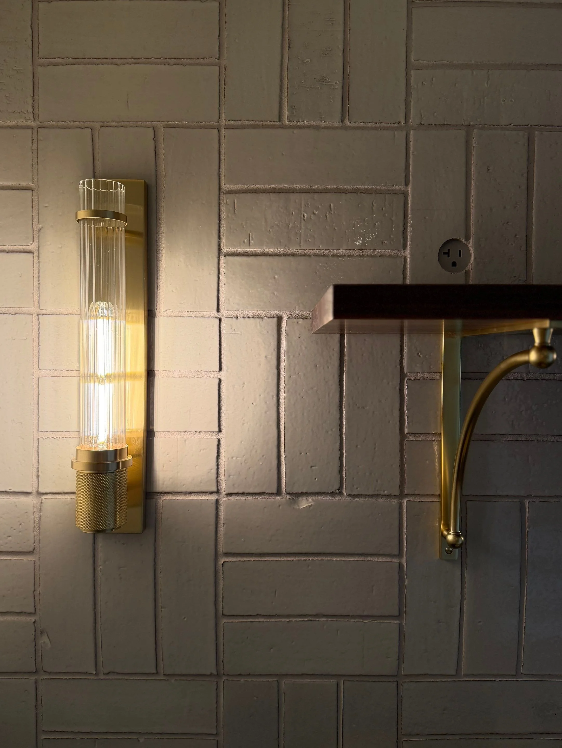 Detail of a brass wall sconce on textured tile — Discovery Park, Seattle whole-home addition