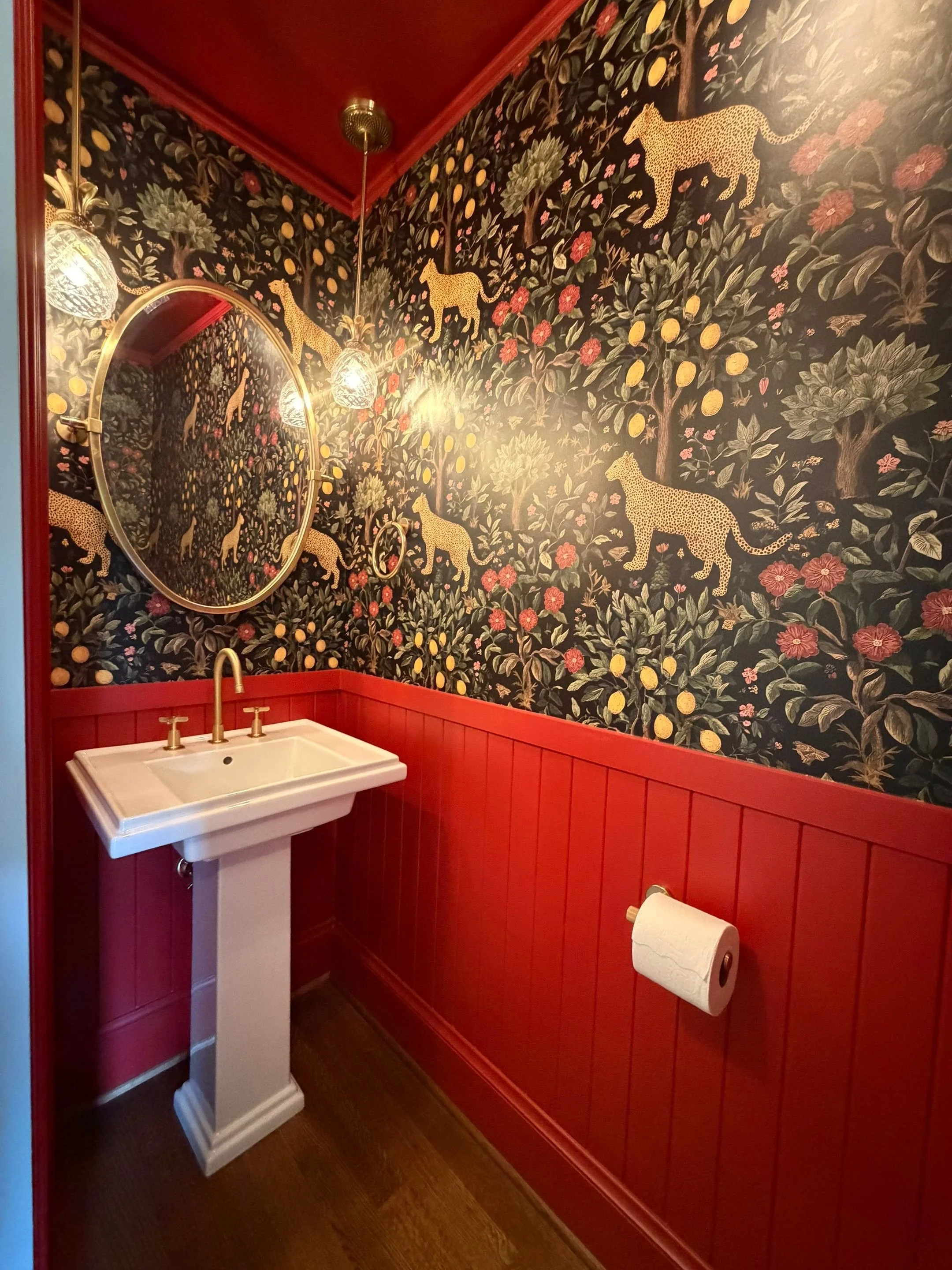 Powder bathroom with bold nature-print wallpaper, red wainscoting, and pedestal sink — Discovery Park, Seattle whole-home addition