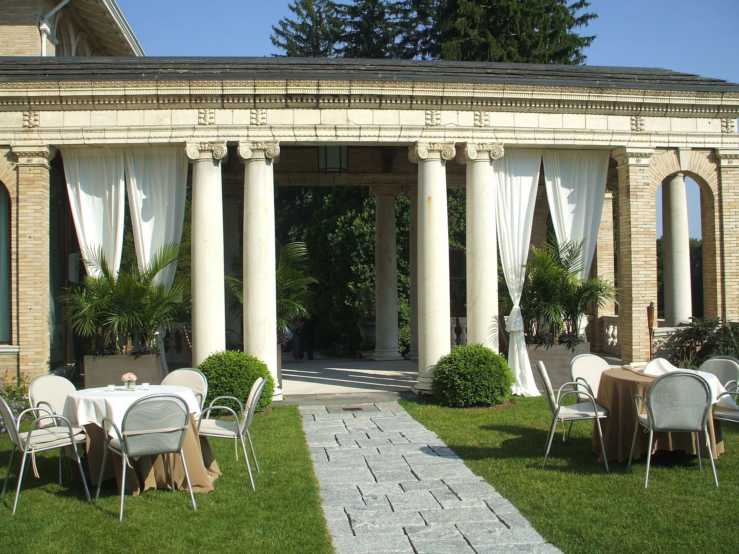 Symmetrical fabric draping on the stone portico of Wheatleigh wedding venue by Berkshire Event Lighting.