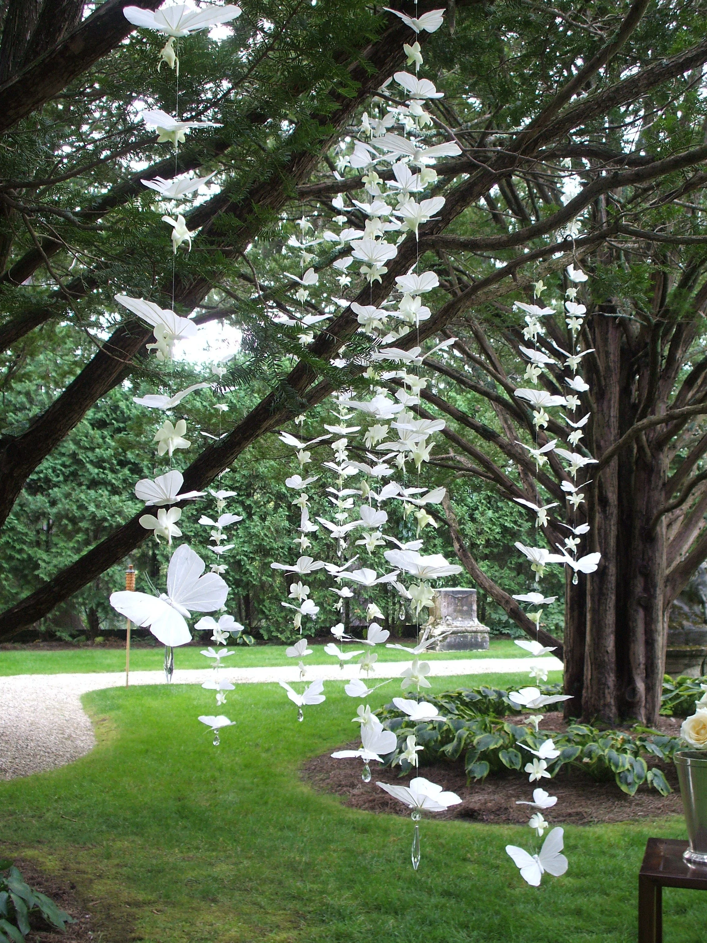 Strands of delicate white decorative butterflies for whimsical wedding and tent decor by Berkshire Event Lighting.