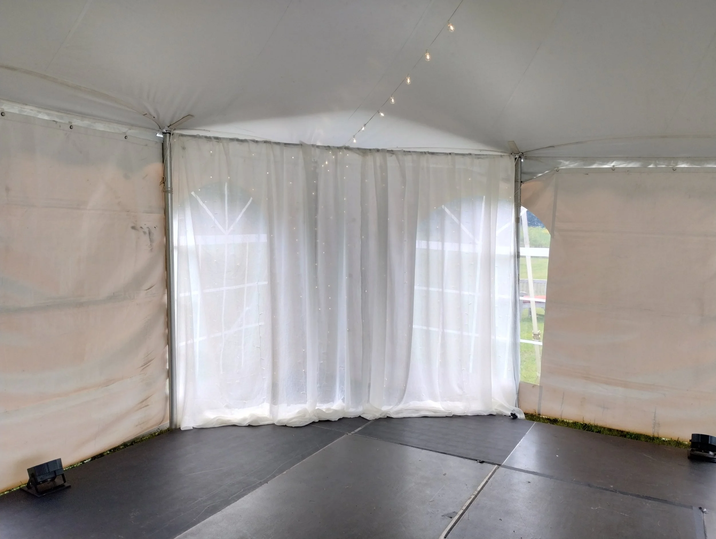 Simple sheer white fabric corner backdrop draped behind a band on an event stage by Berkshire Event Lighting.