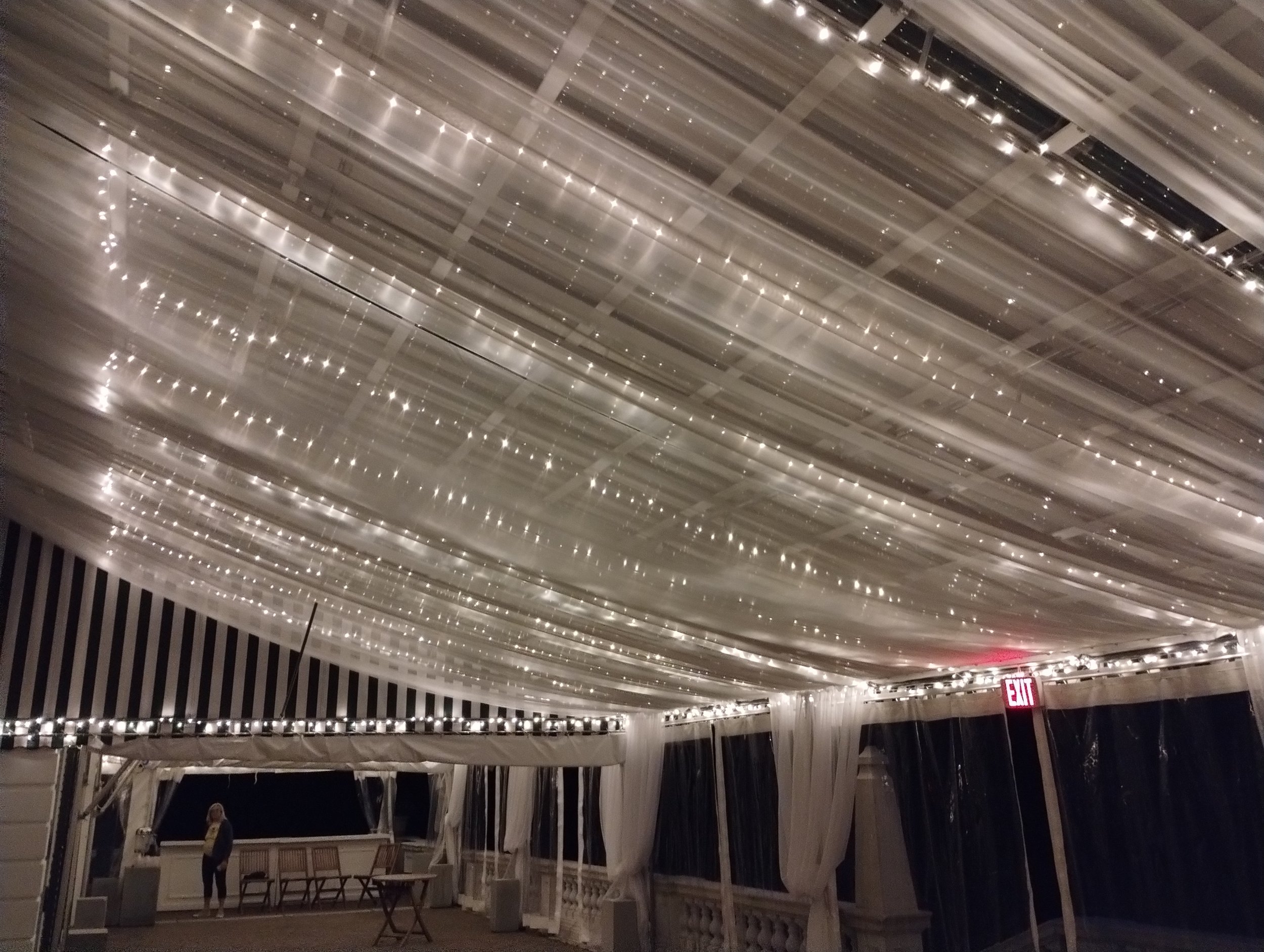 Evening shot of terrace tent at The Mount venue, fully lined and draped in sheer fire retardant voile fabric by Berkshire Event Lighting.