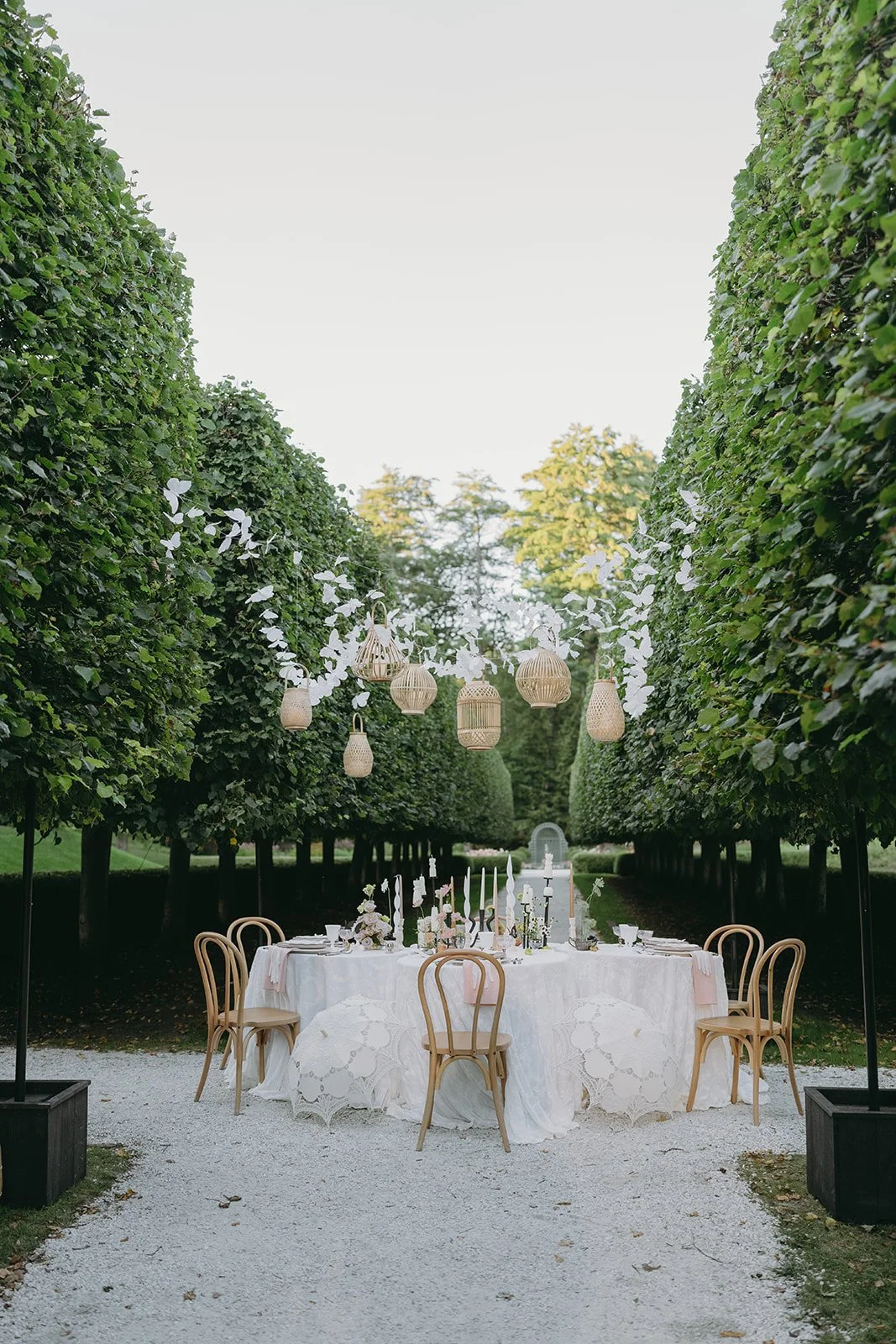 Custom bamboo lantern and butterfly light installation over an elegant dining table in the Lime Walk at The Mount, Lenox MA, by Berkshire Event Lighting.
