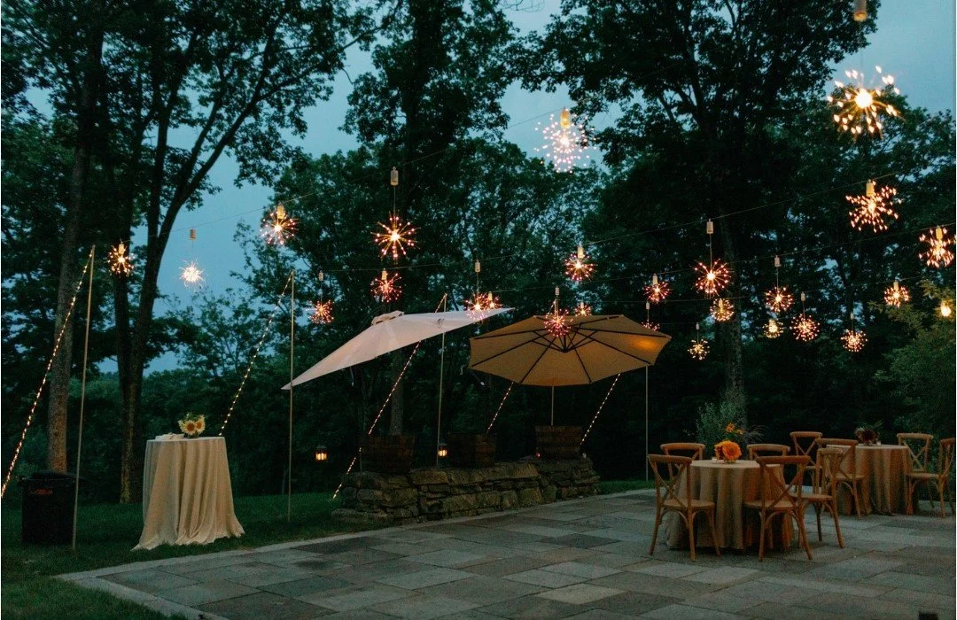 Outdoor patio cocktail lighting featuring firework burst lights and a custom pole rigging system in the Berkshires, by Berkshire Event Lighting.